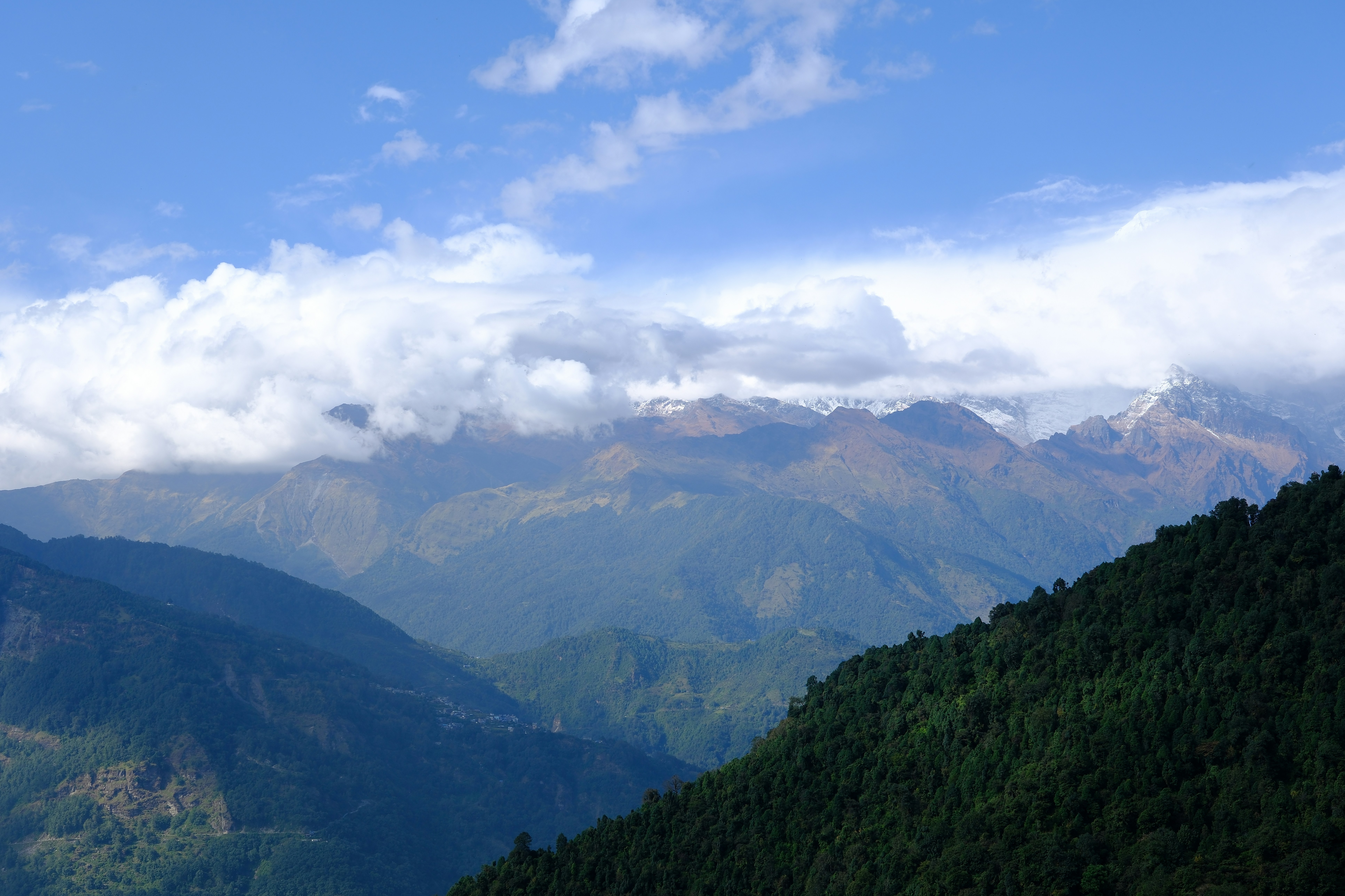 A scenic view of a mountain range with clouds in the sky