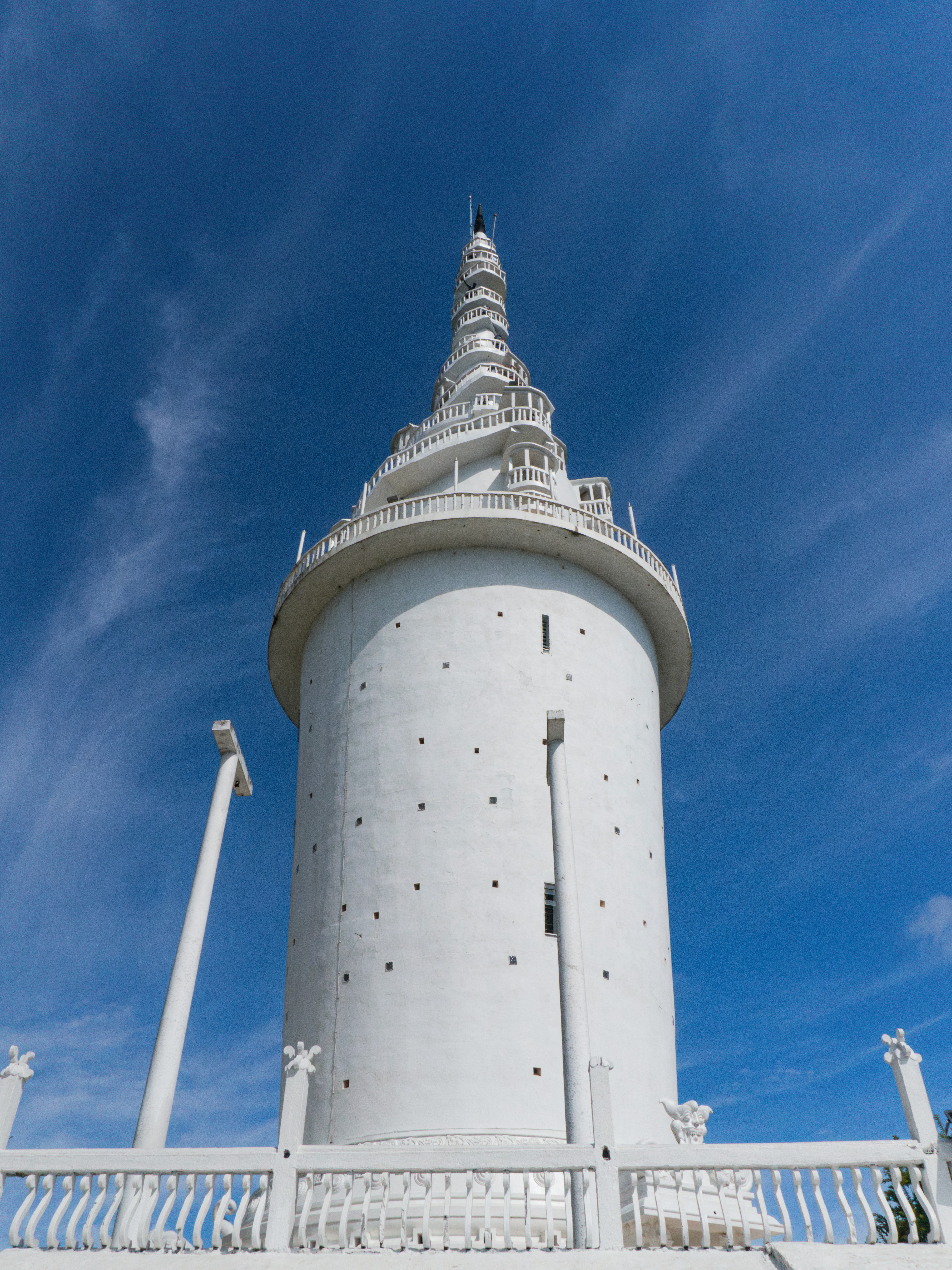 A tall white tower with a sky background