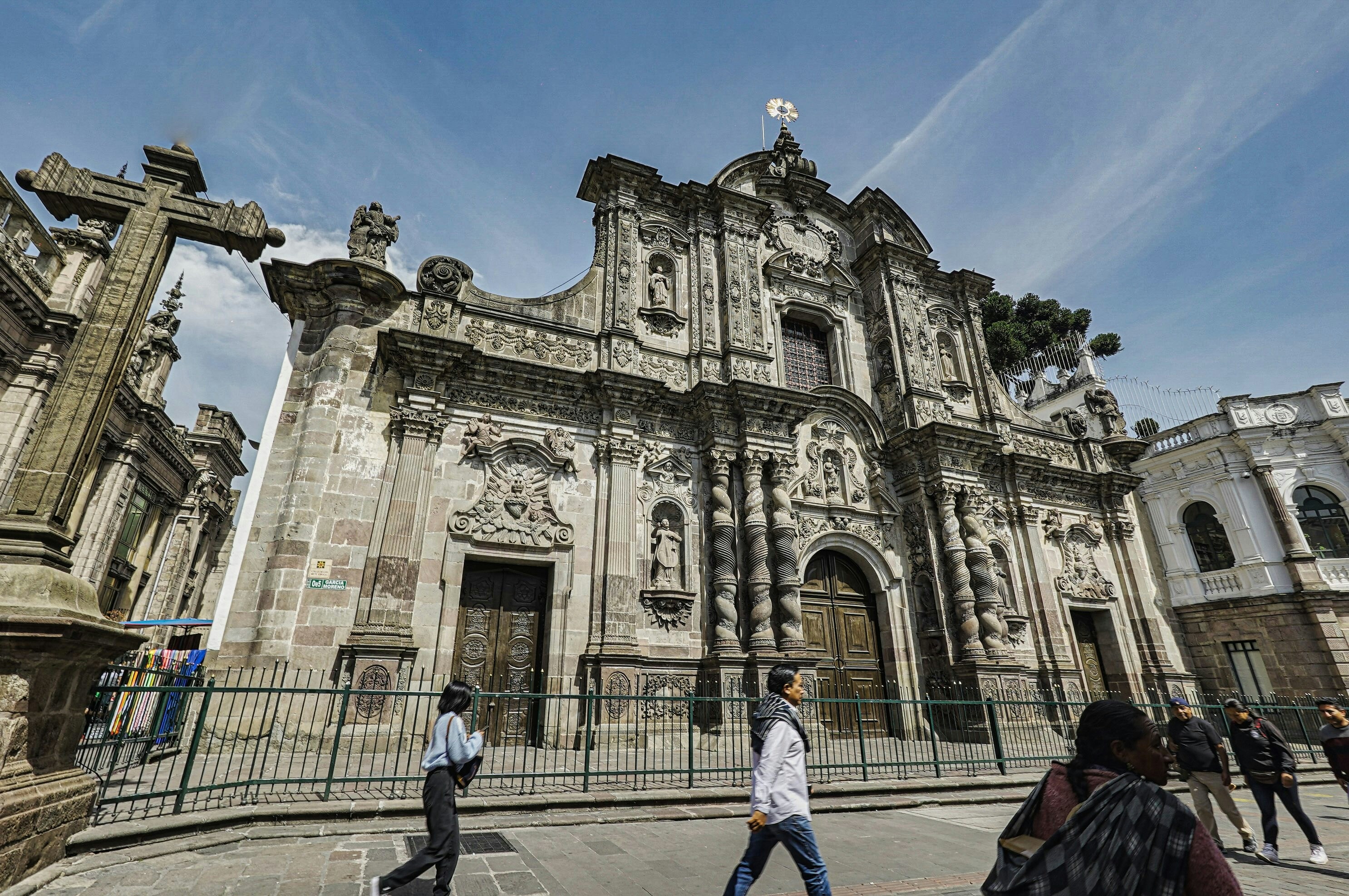 A group of people walking in front of a large building