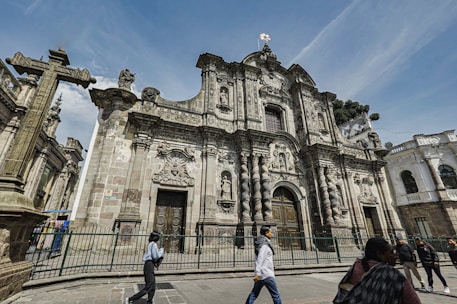 A group of people walking in front of a large building