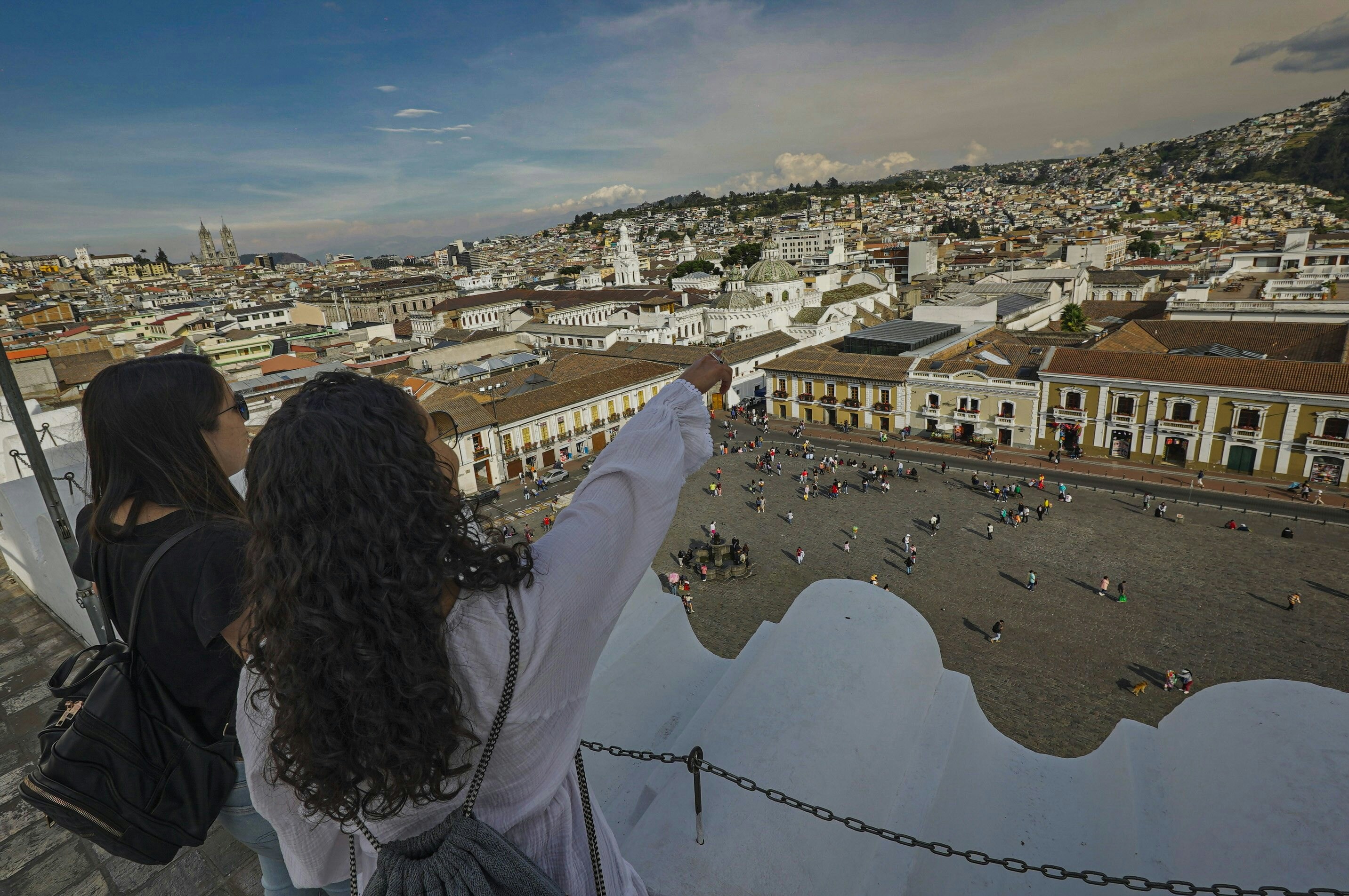 A couple of women standing on top of a roof