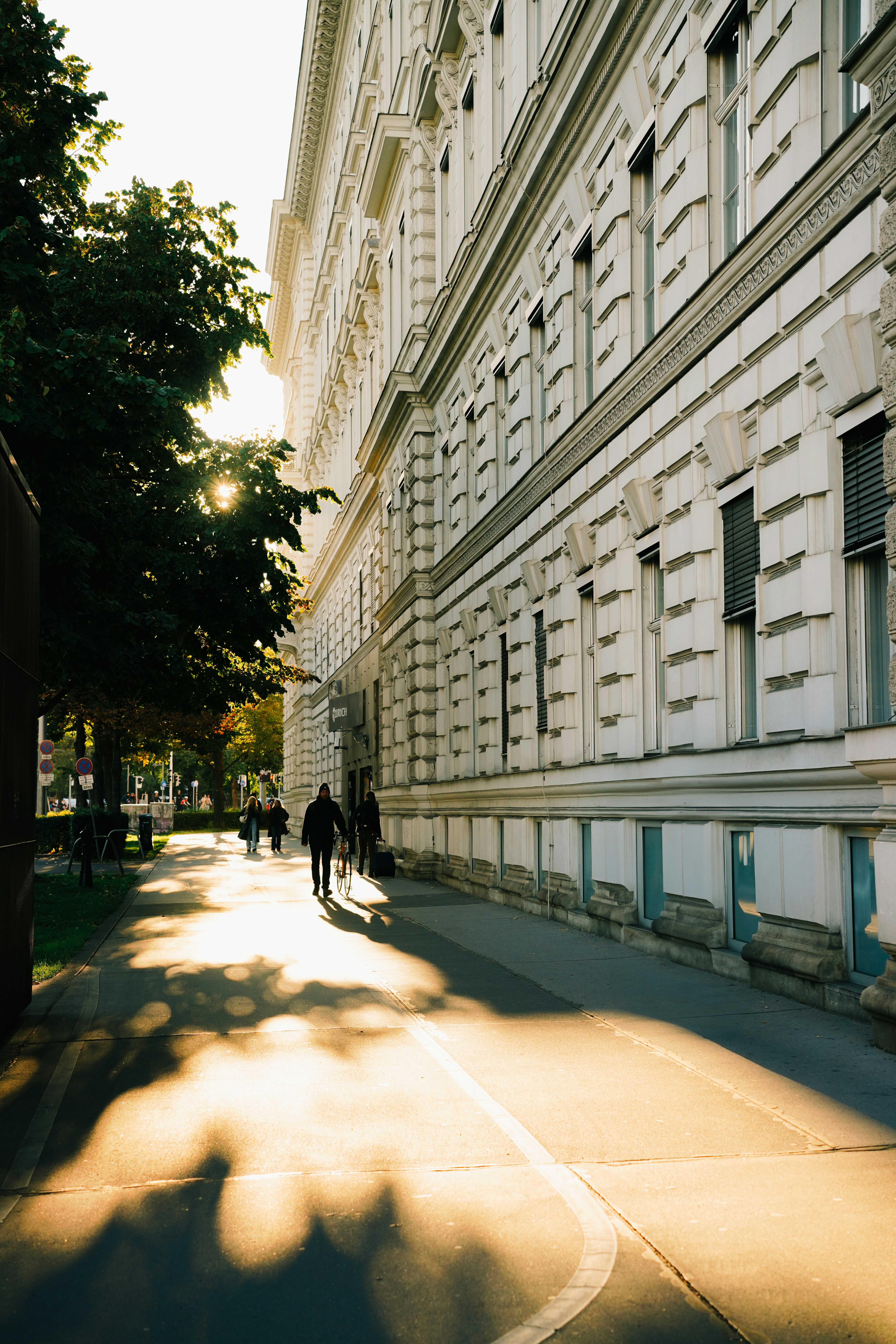 A person walking down a street next to a tall building