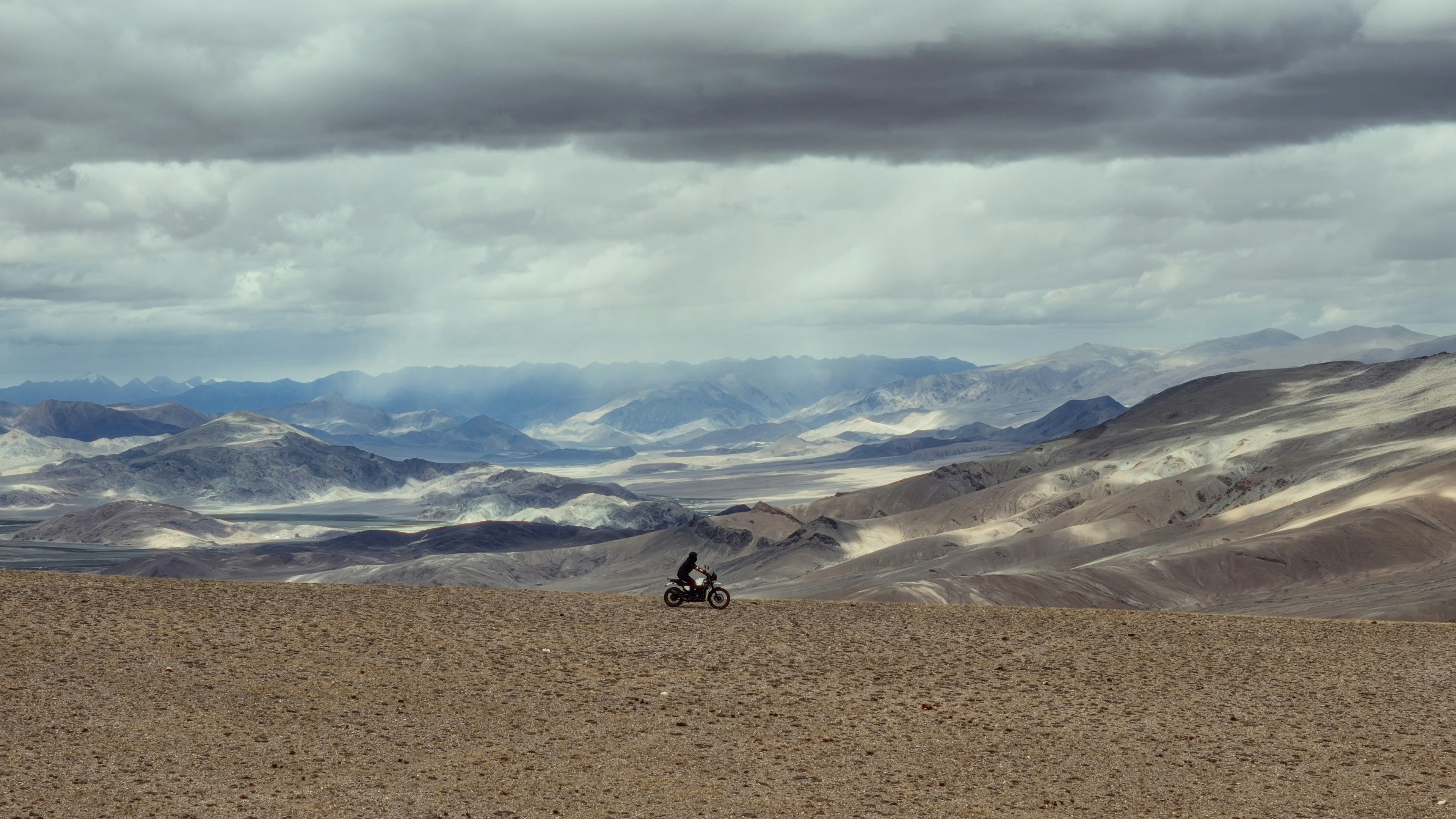 A person is flying a kite in the mountains