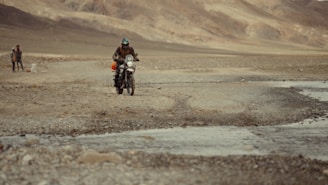 A man riding a motorcycle down a dirt road
