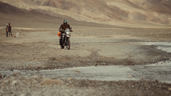 A man riding a motorcycle down a dirt road