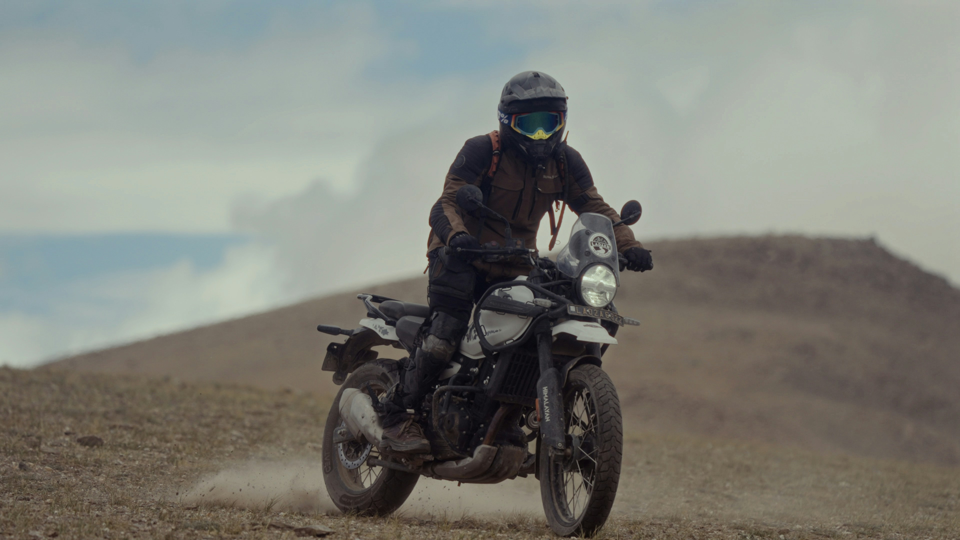 A man riding a motorcycle down a dirt road
