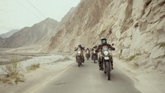 A group of people riding motorcycles down a road