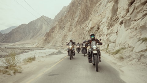 A group of people riding motorcycles down a road