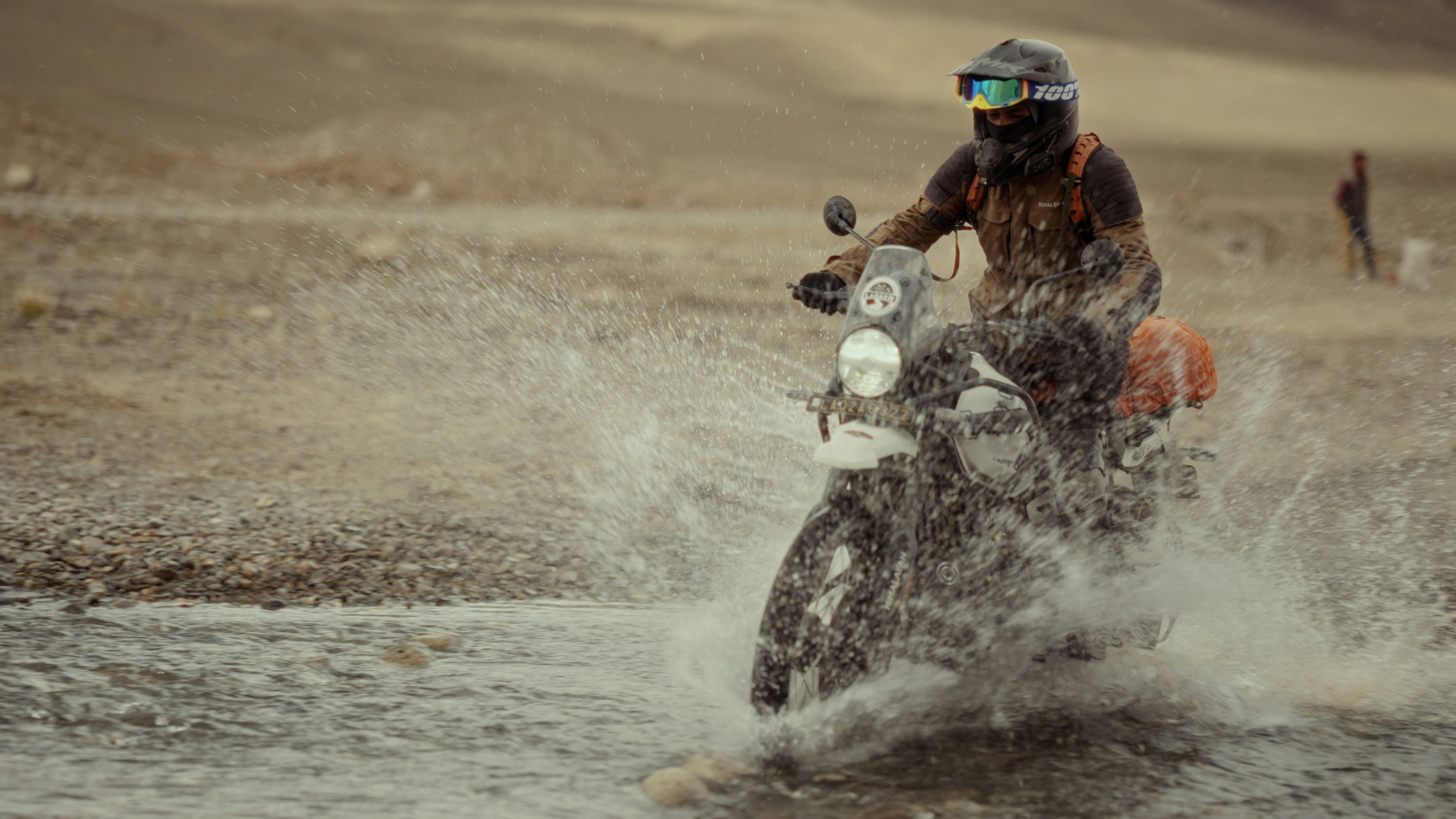 Adventure bike crossing water in a scenic Colorado landscape