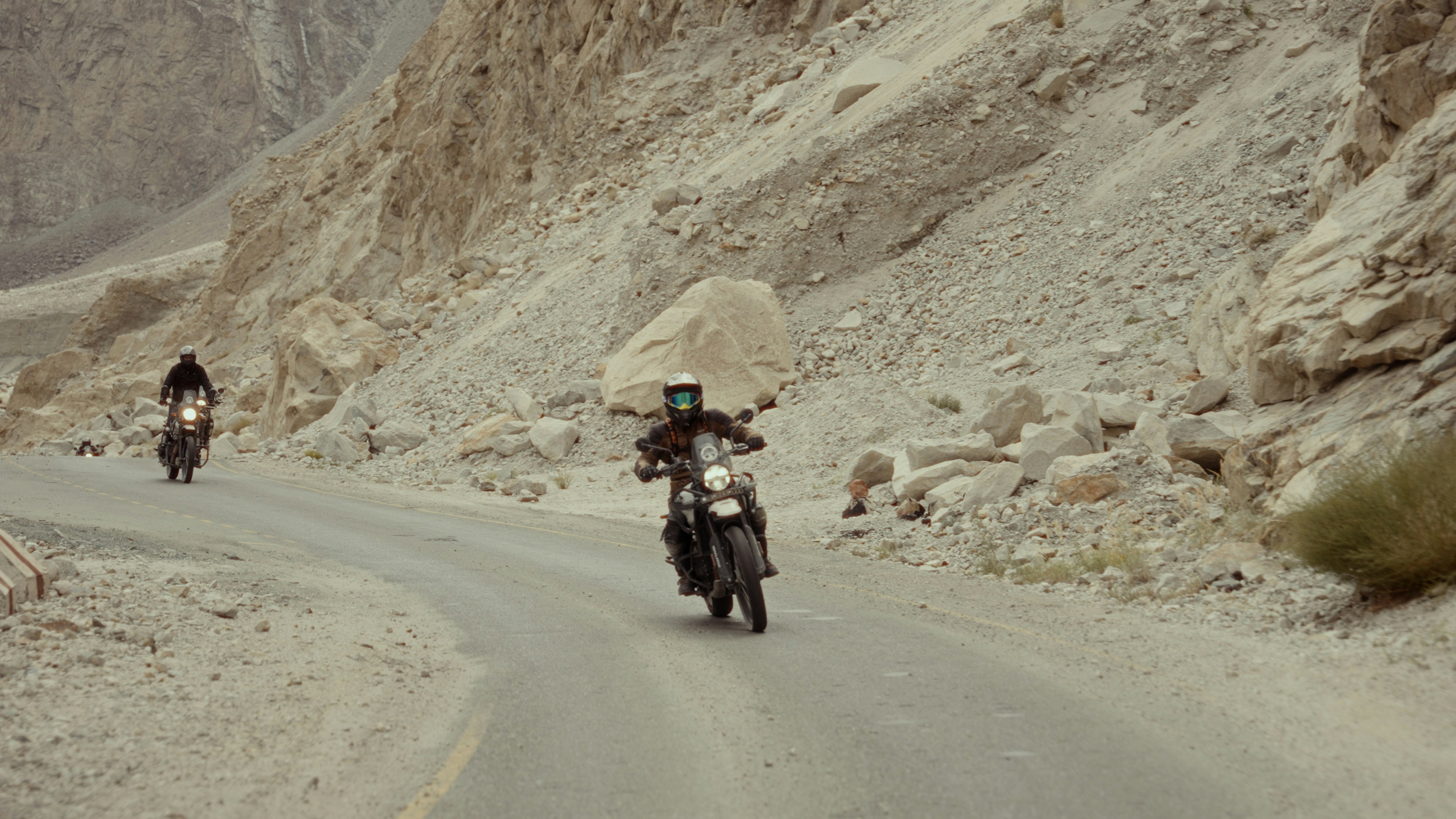 A group of people riding motorcycles down a mountain road