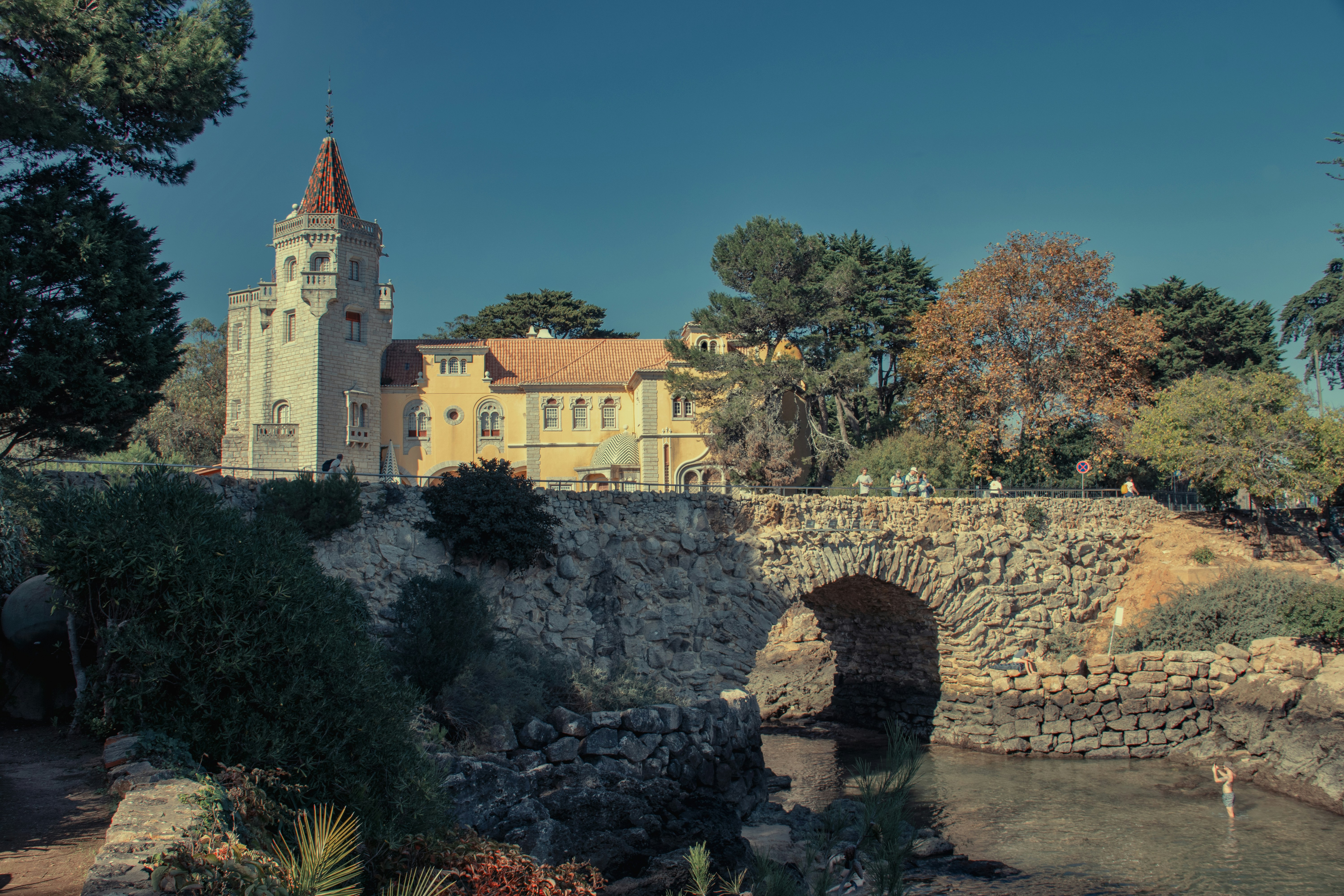 A small bridge over a small river with a church in the background