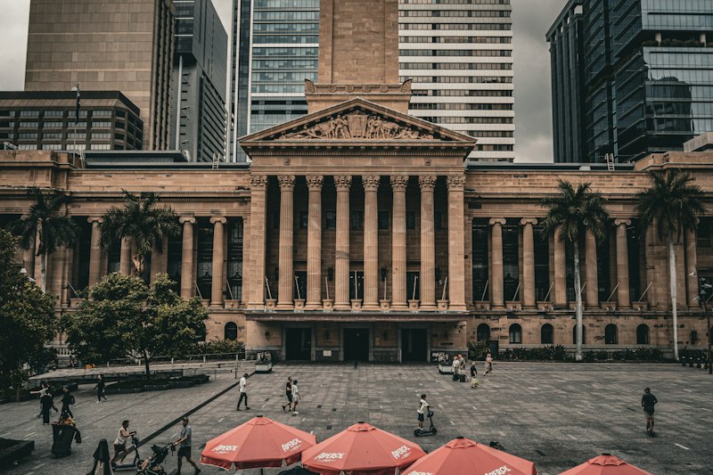 A large building with many red umbrellas in front of it