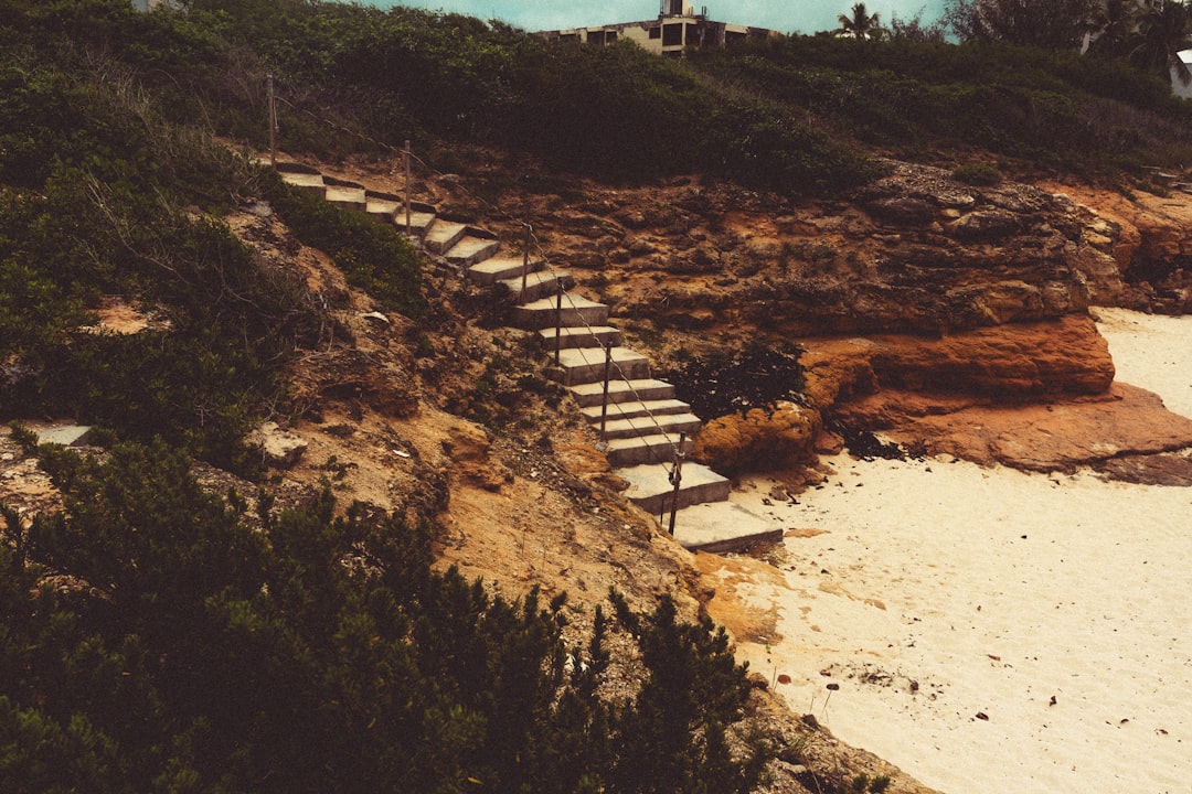 A beach with steps leading to a lighthouse,