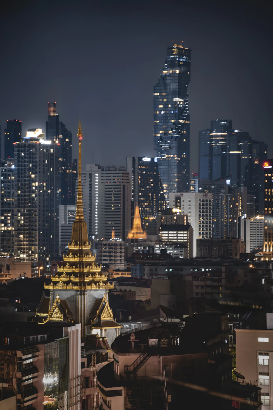Ornate temple rooftop against the modern Bangkok skyline