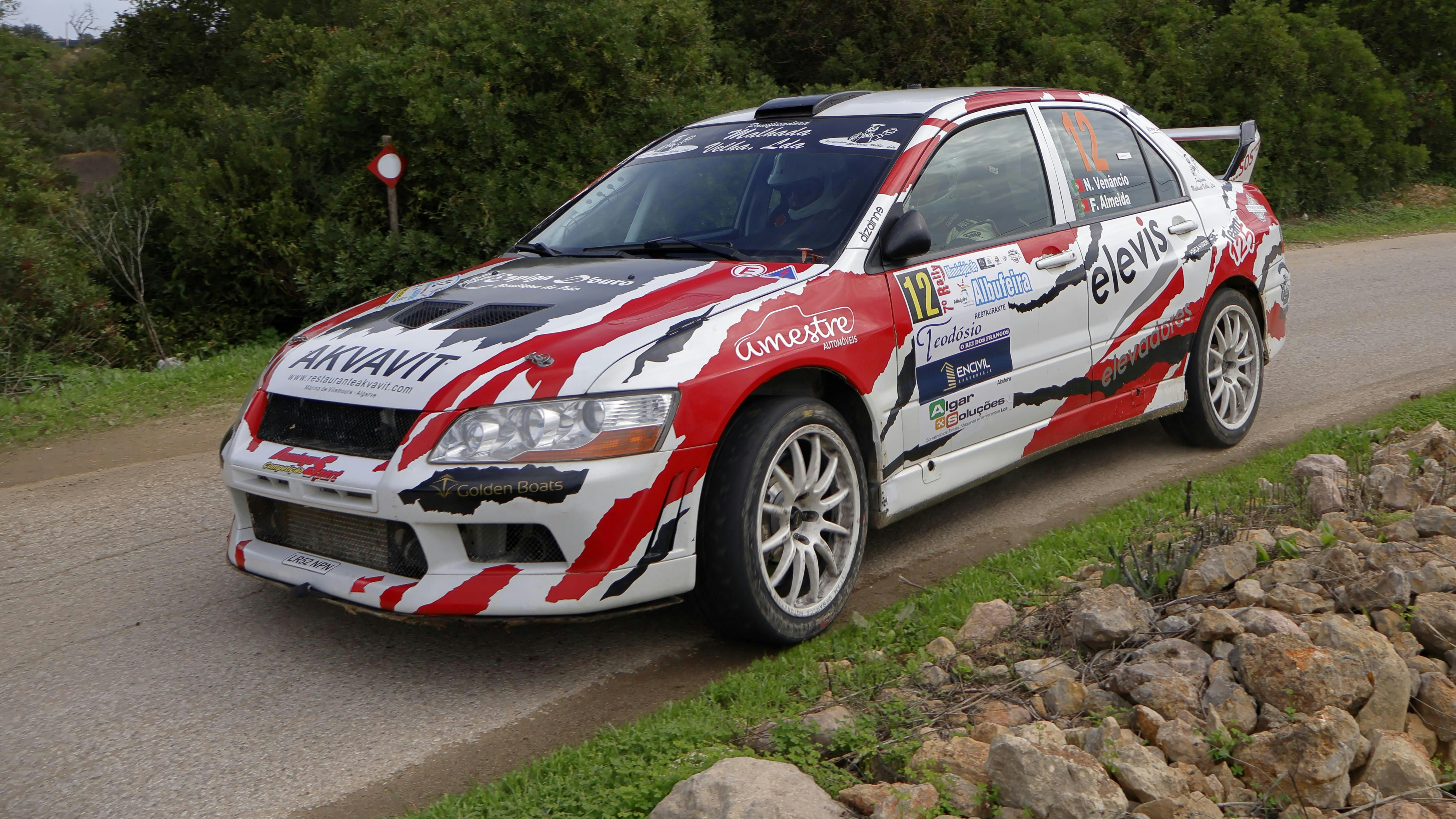 A red and white car driving down a road