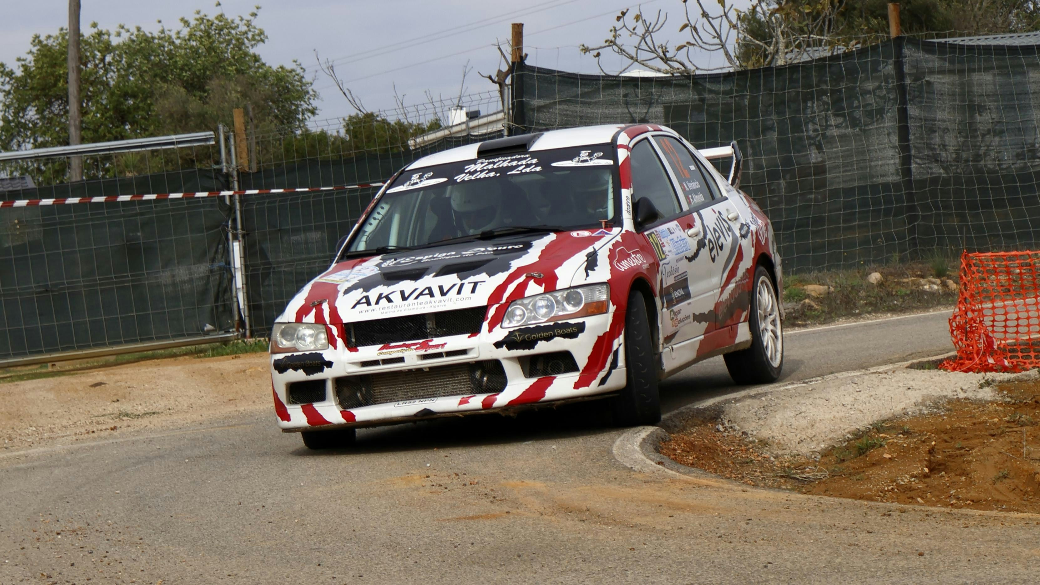 A white and red car driving down a road