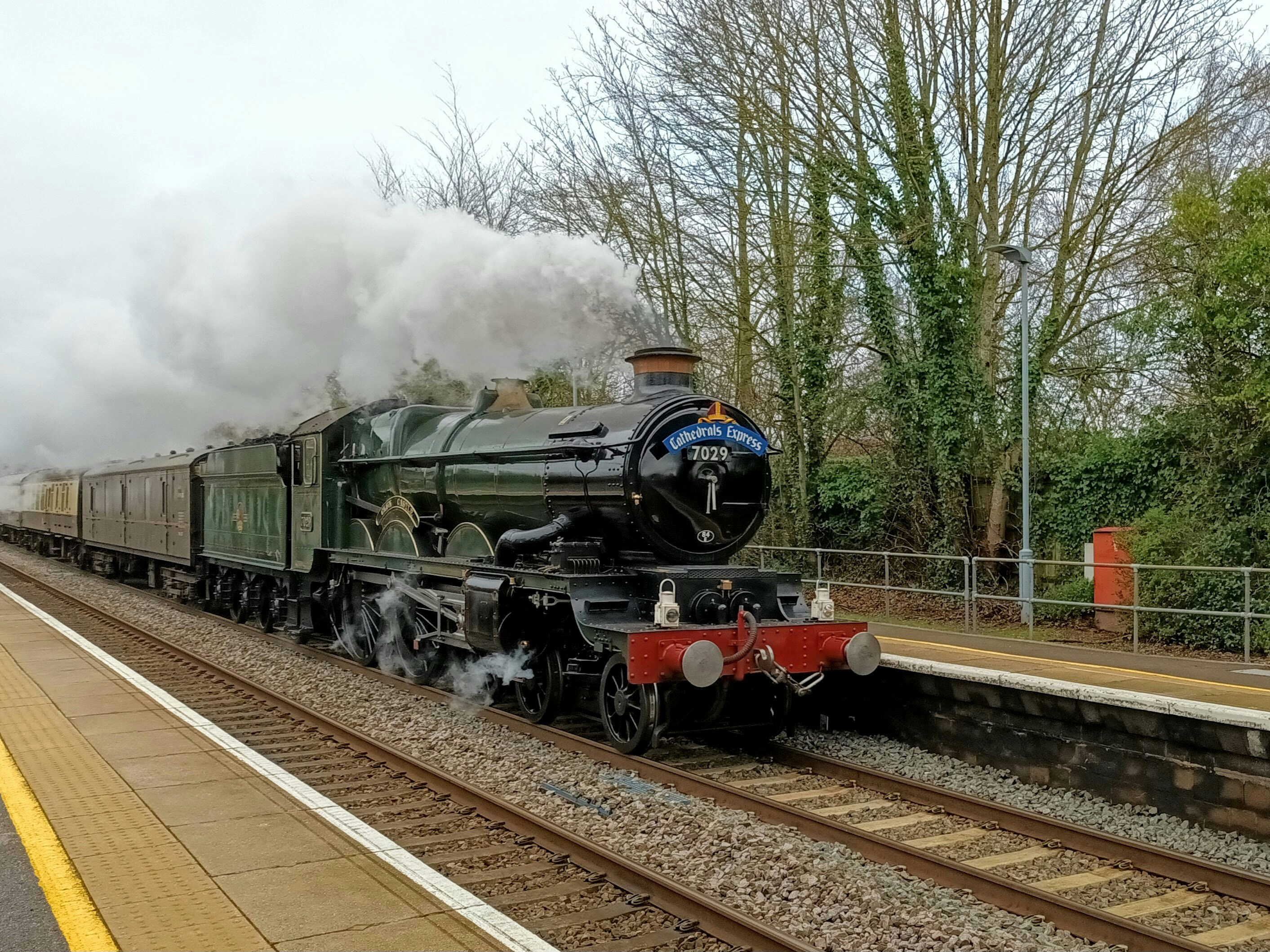 Green painted mixed traffic steam locomotive at station, steam billowing, wartime atmosphere