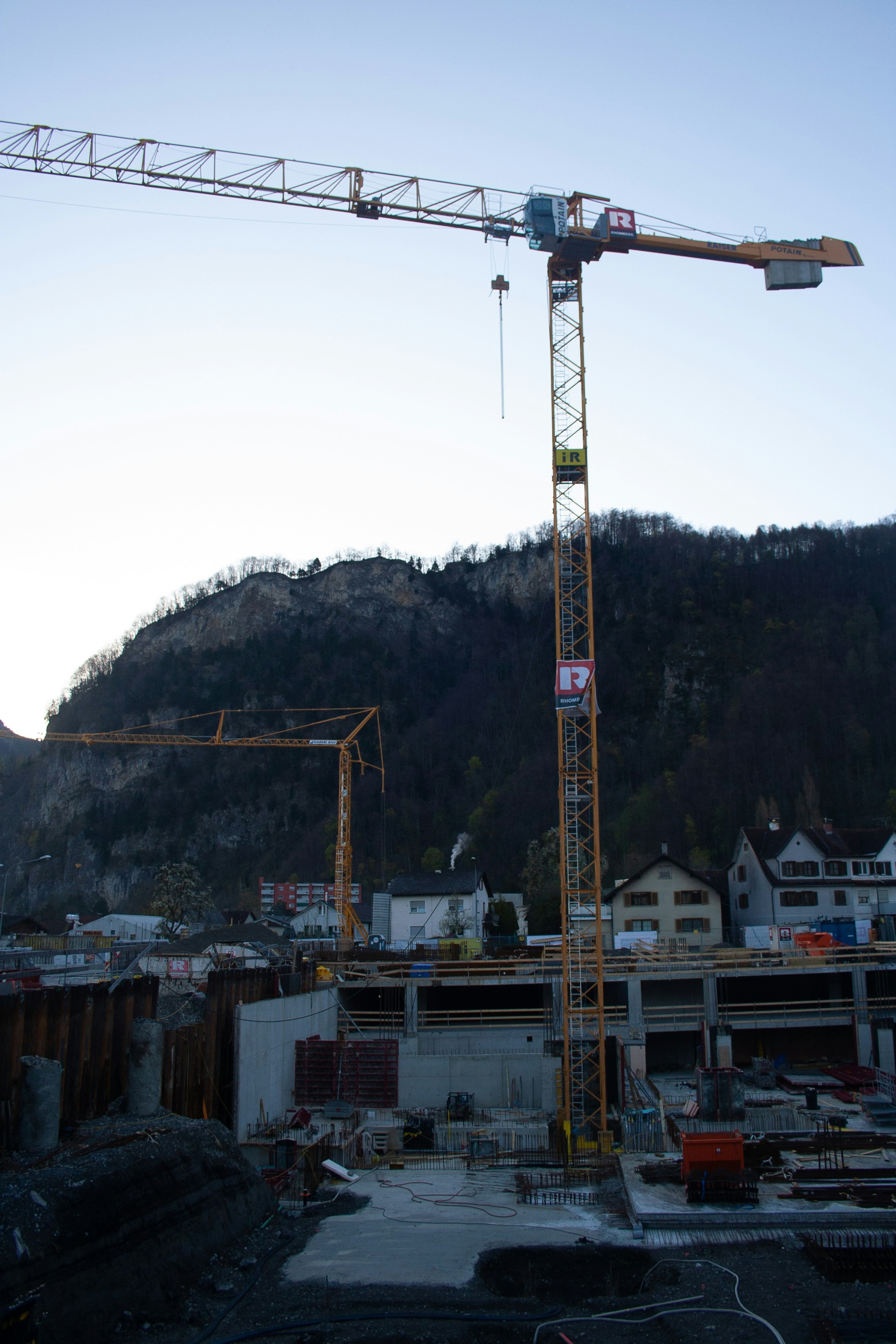 A crane is standing in front of a construction site