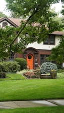A house with a red door and a green lawn
