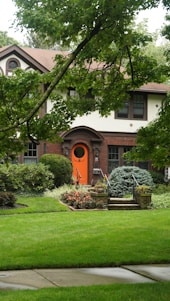 A house with a red door and a green lawn