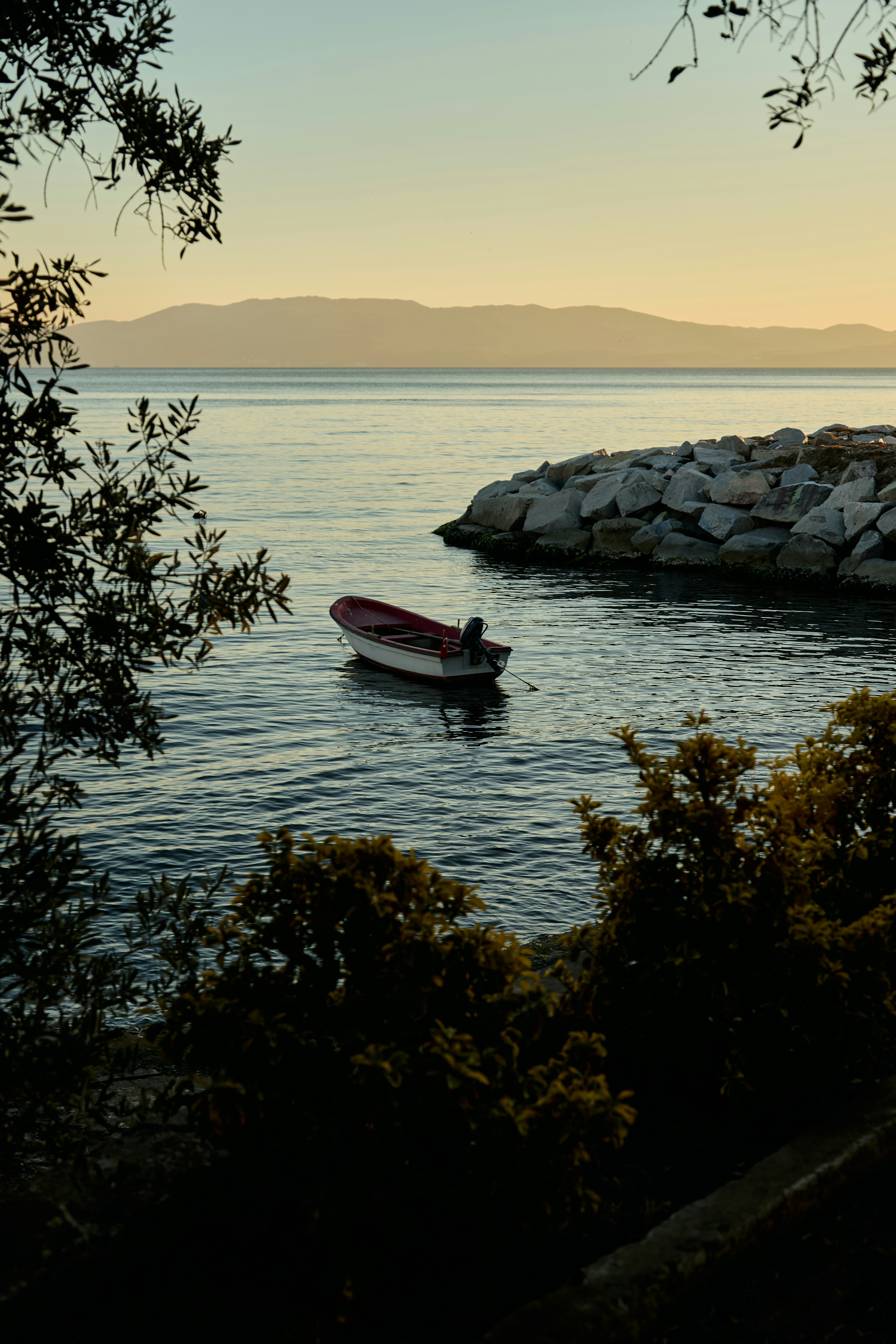 A small boat floating on top of a body of water photo – Free Rock Image ...