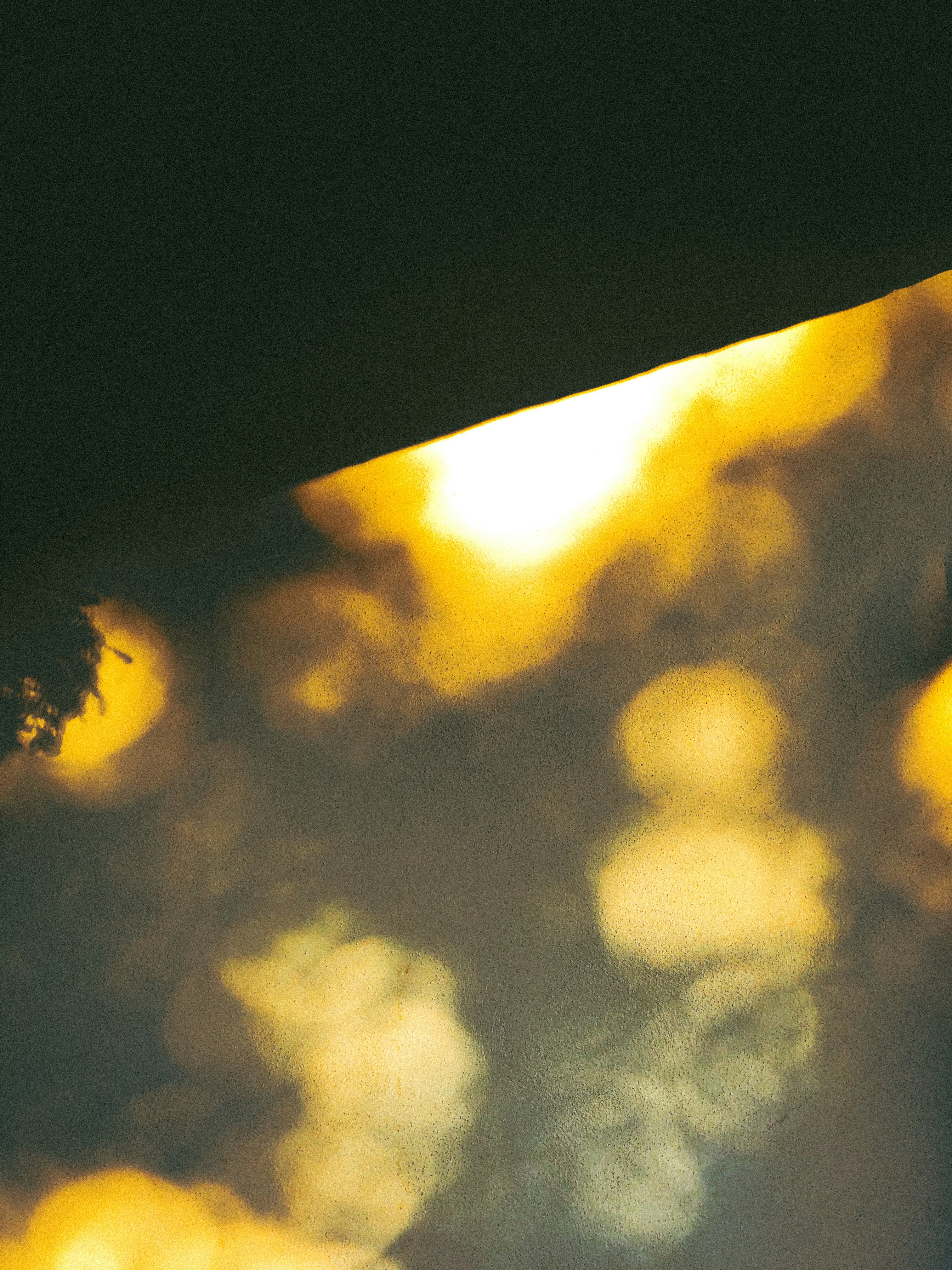 Abstract canvas with luminous golden yellow and soft grey tones, resin layers creating depth, natural light from window