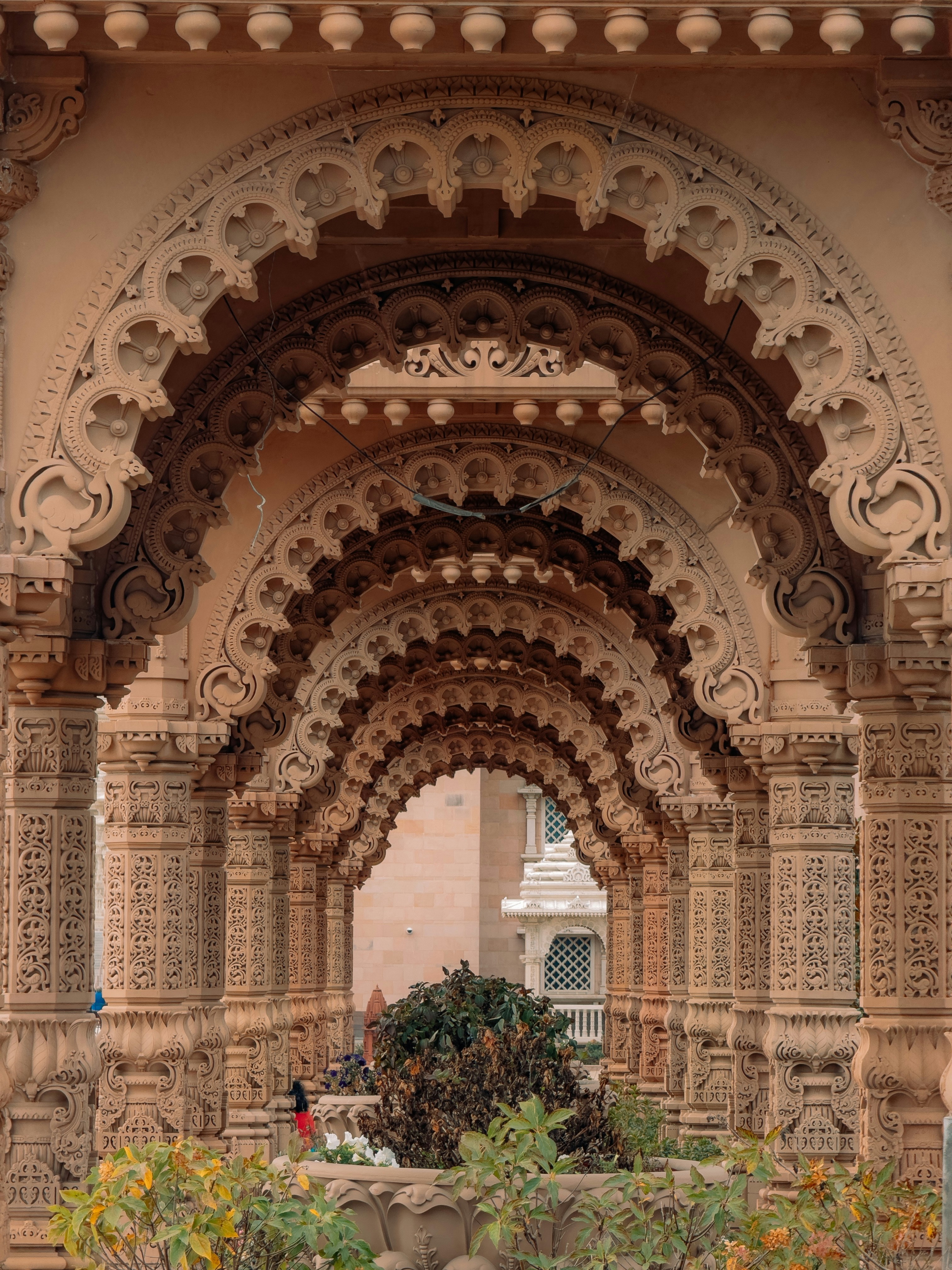 Repetitive classical stone colonnade and arched hallway in warm golden afternoon light