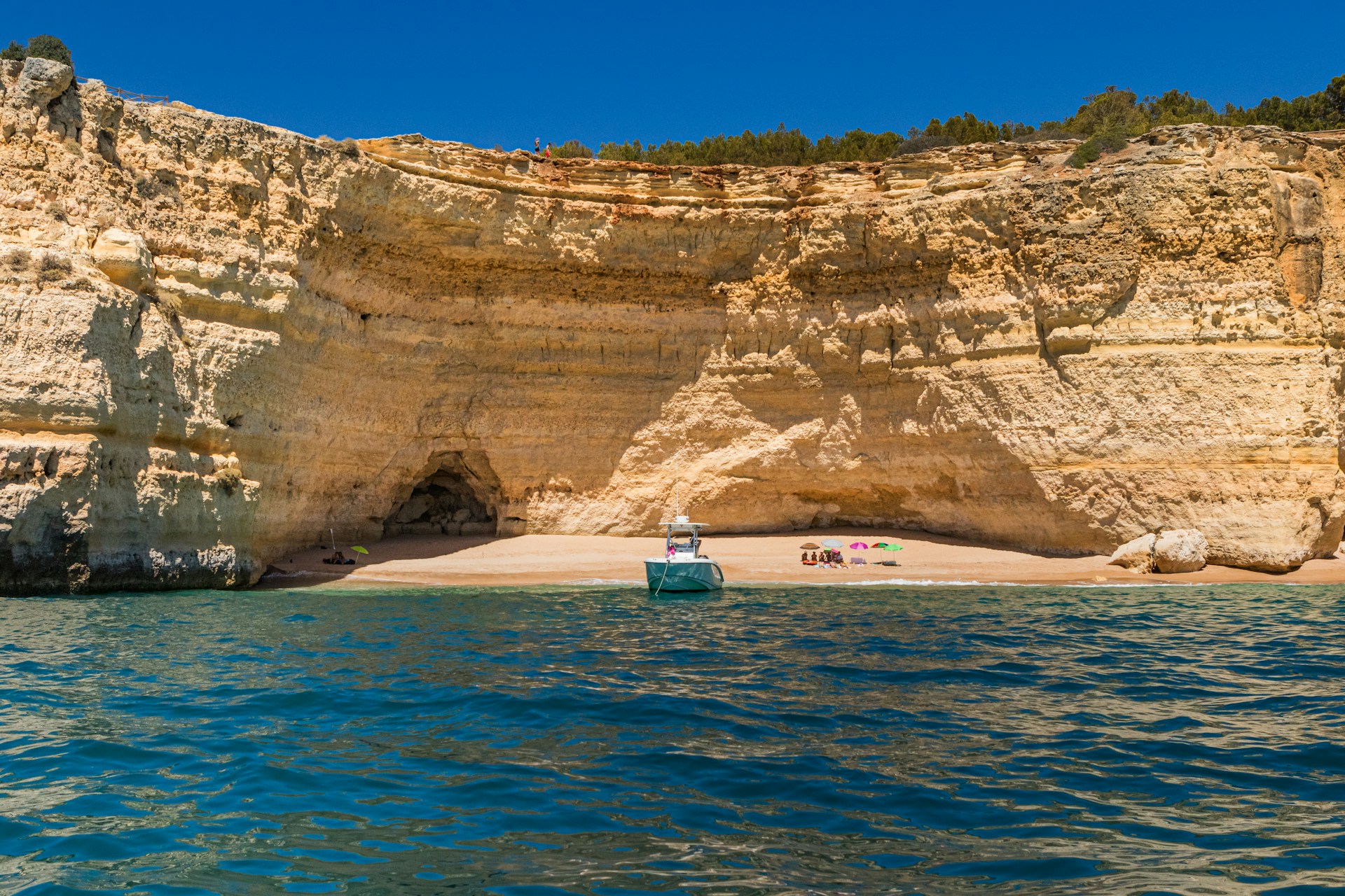 A boat is in the water near a rocky cliff