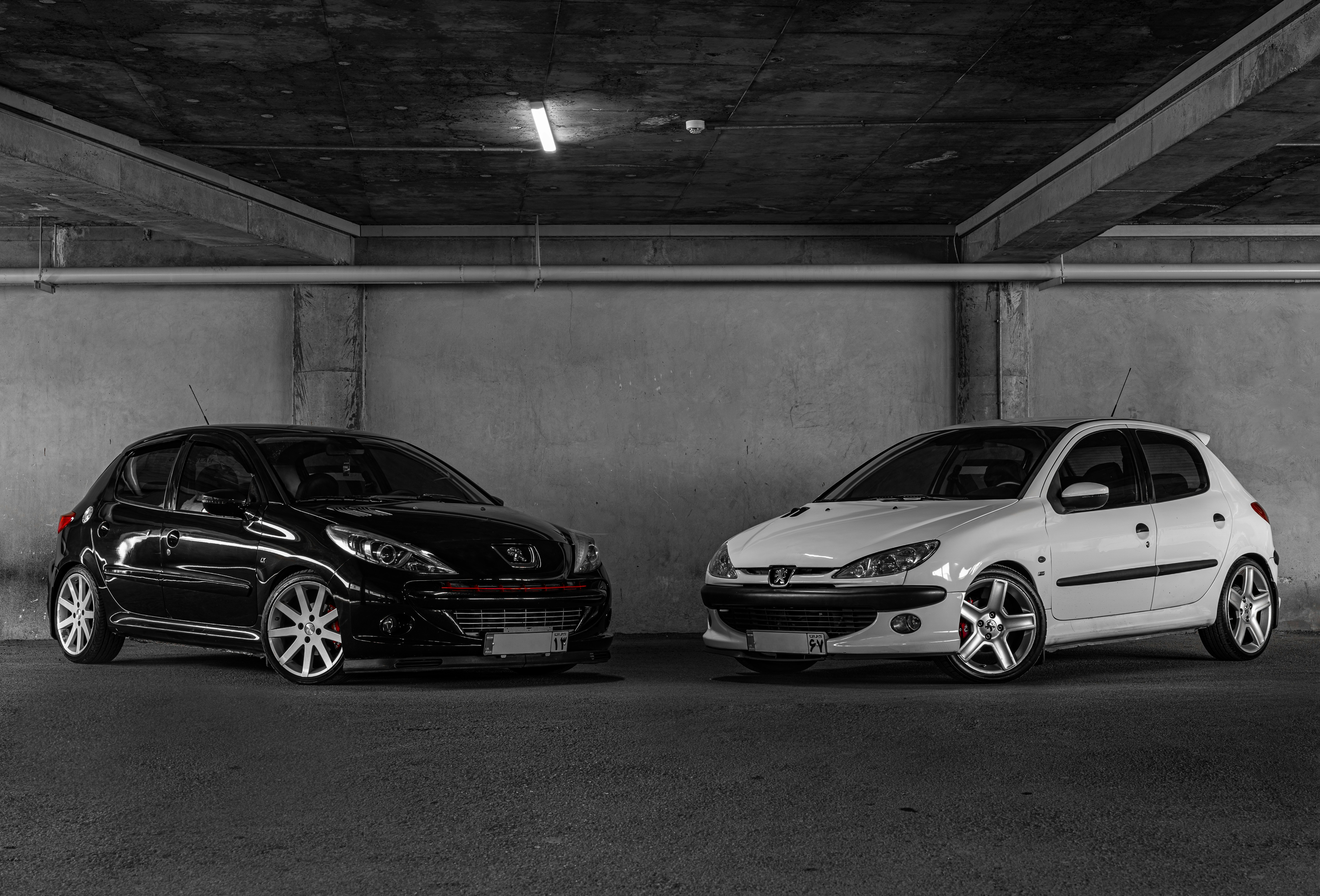 Two cars parked in a parking garage next to each other