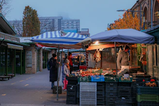 A group of people walking down a street next to a market