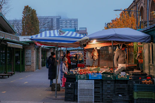 A group of people walking down a street next to a market