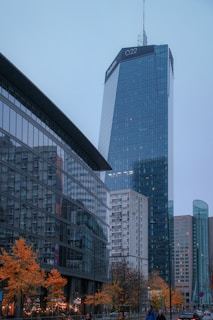A group of people walking down a street next to tall buildings