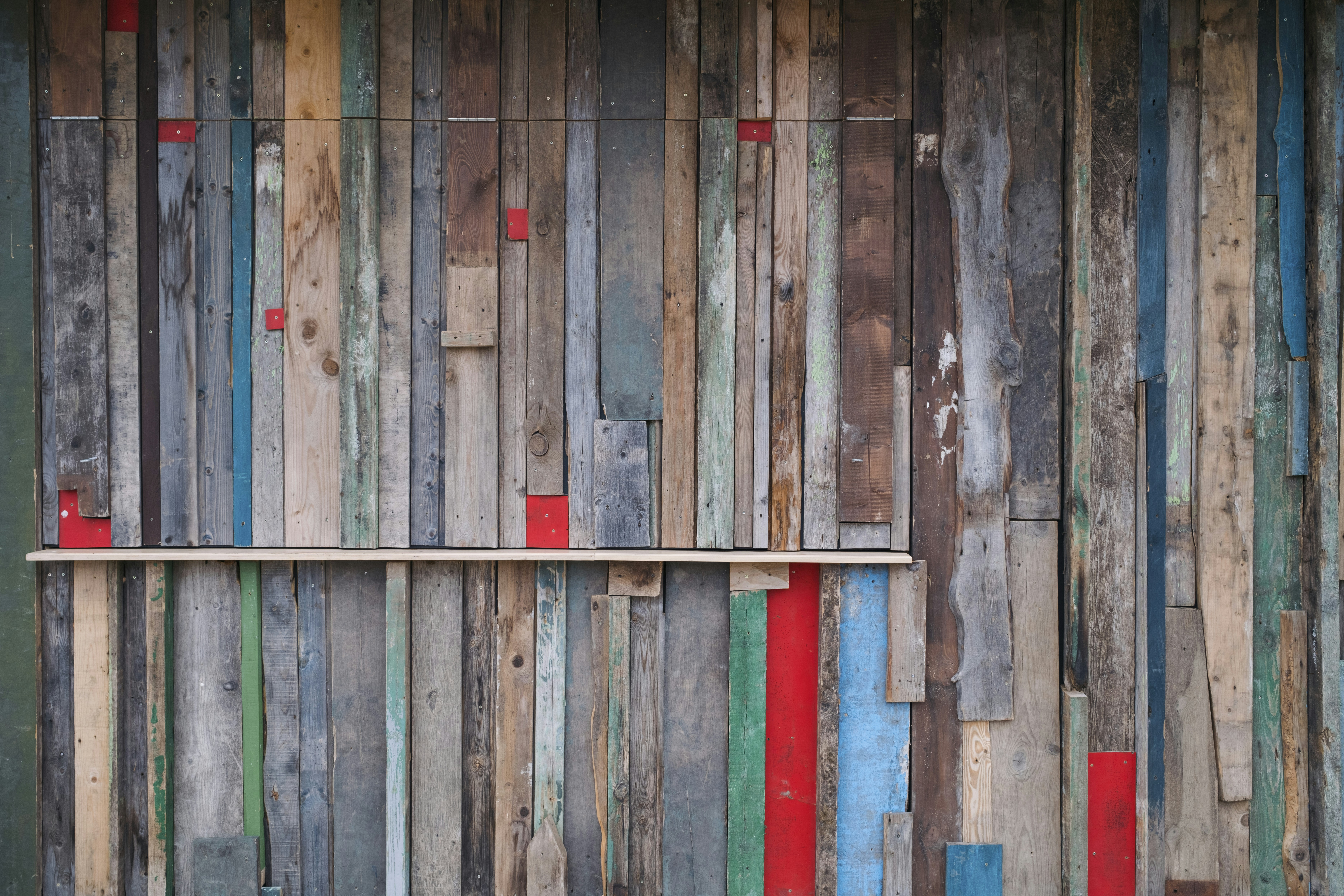 A wooden wall with a shelf in the middle of it