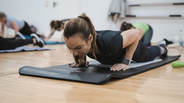 A group of people in a gym doing push ups
