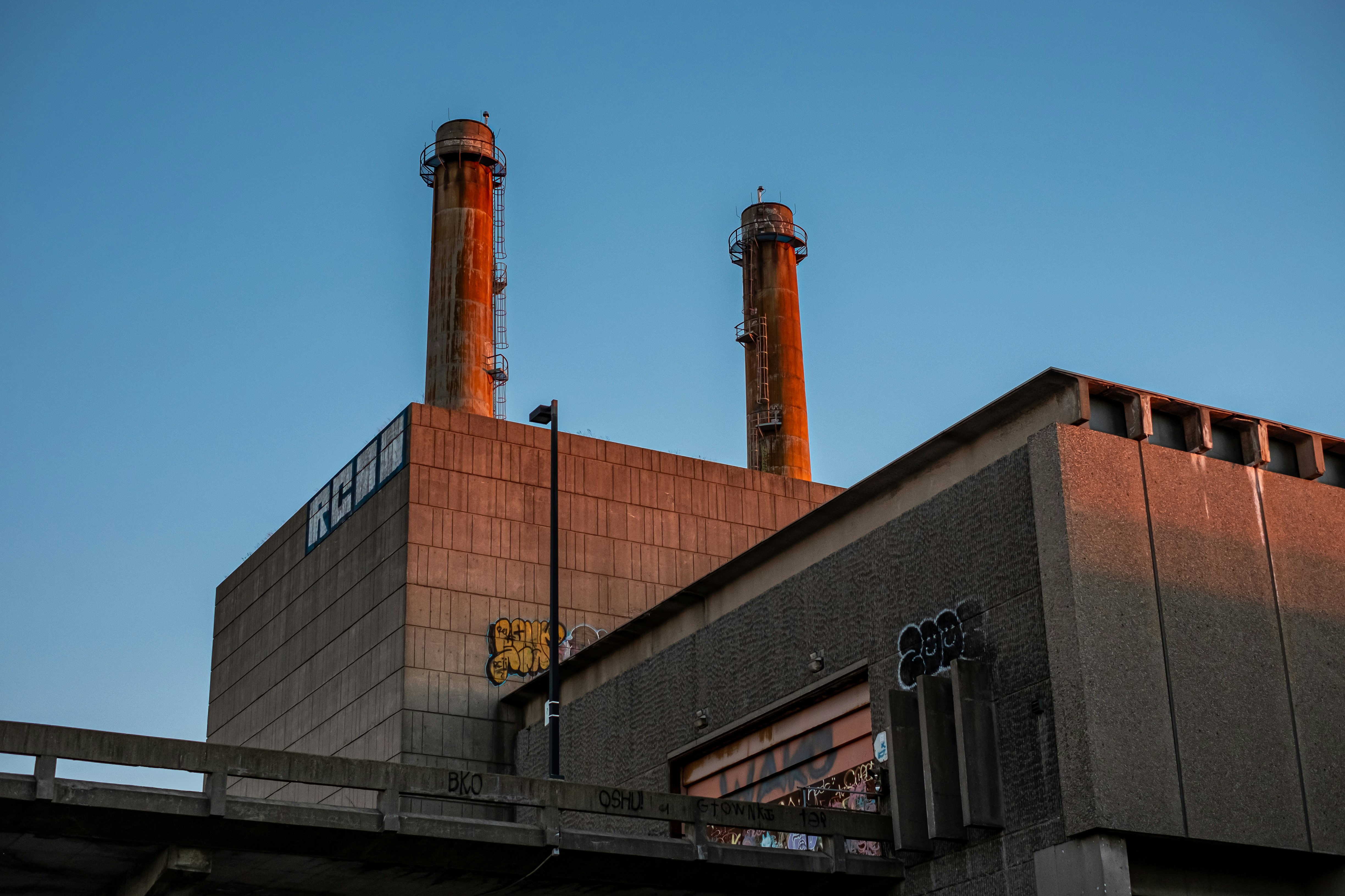 A factory building with two chimneys and a blue sky in the background