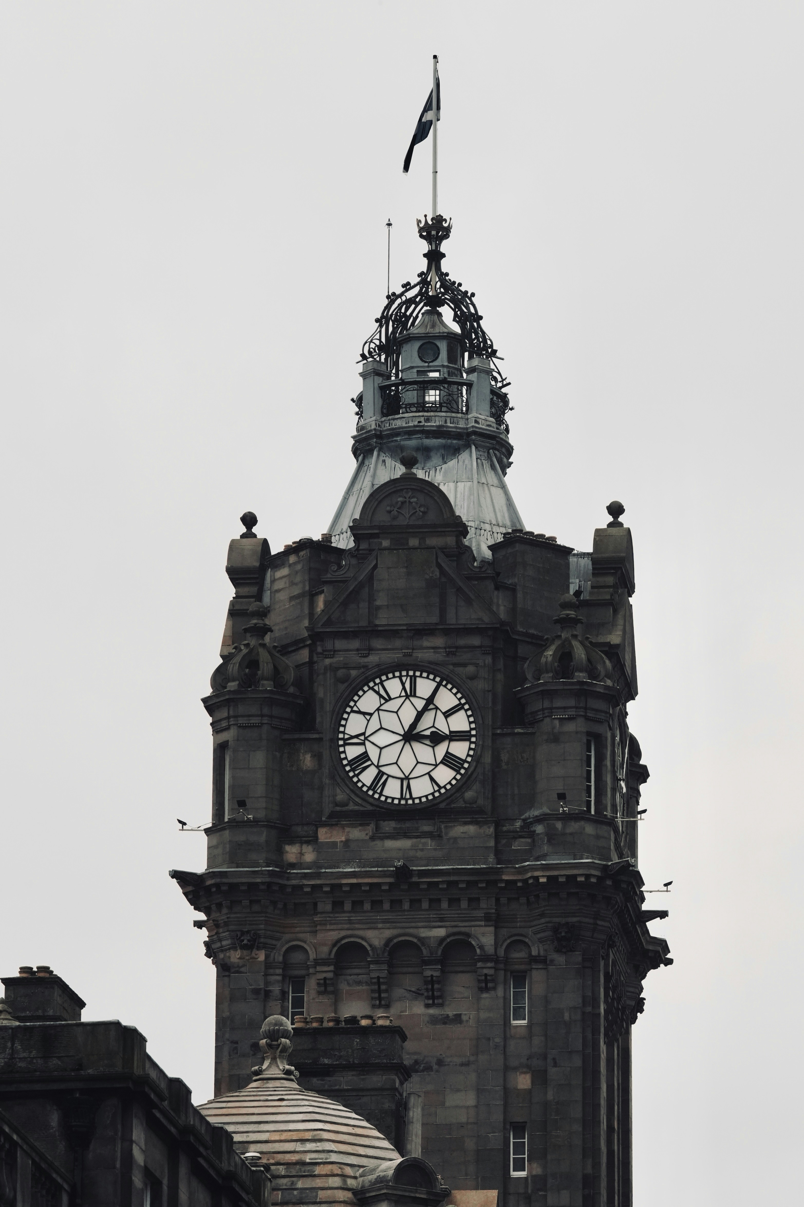A clock tower with a flag on top of it