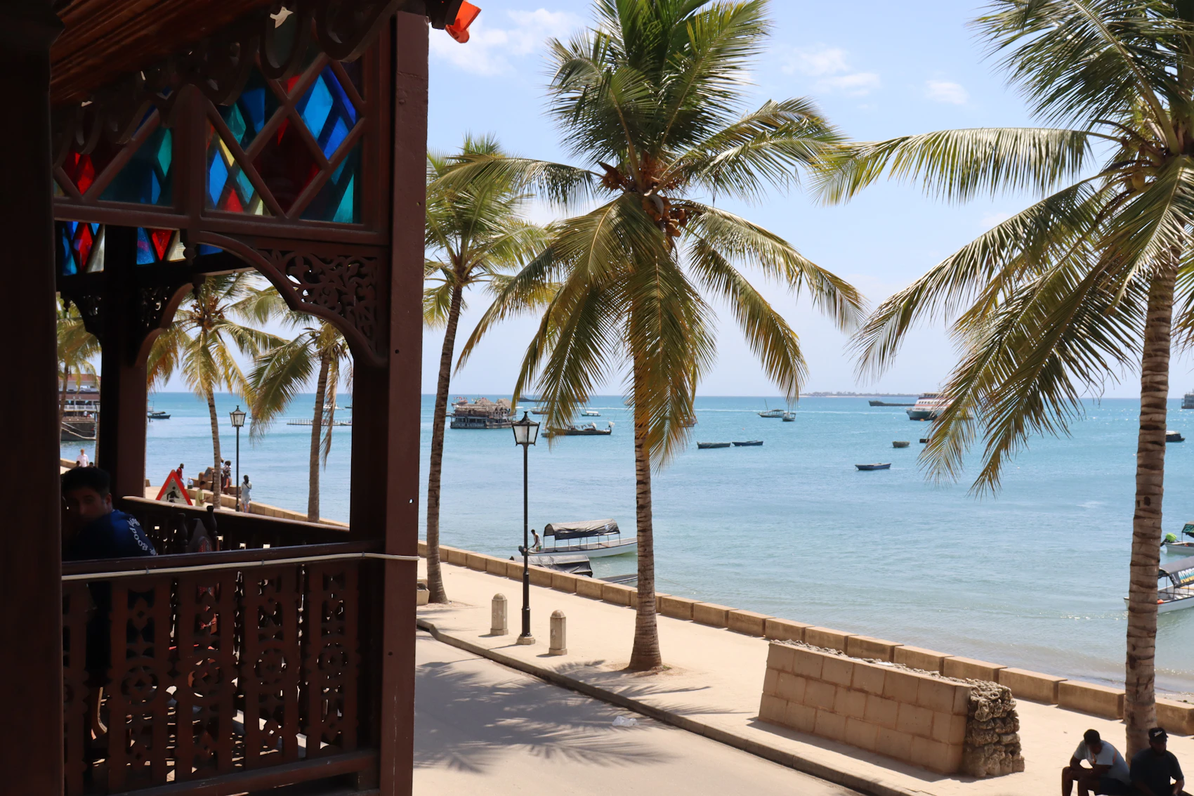 Stone Town's seafront and palm trees beneath a tropical sky