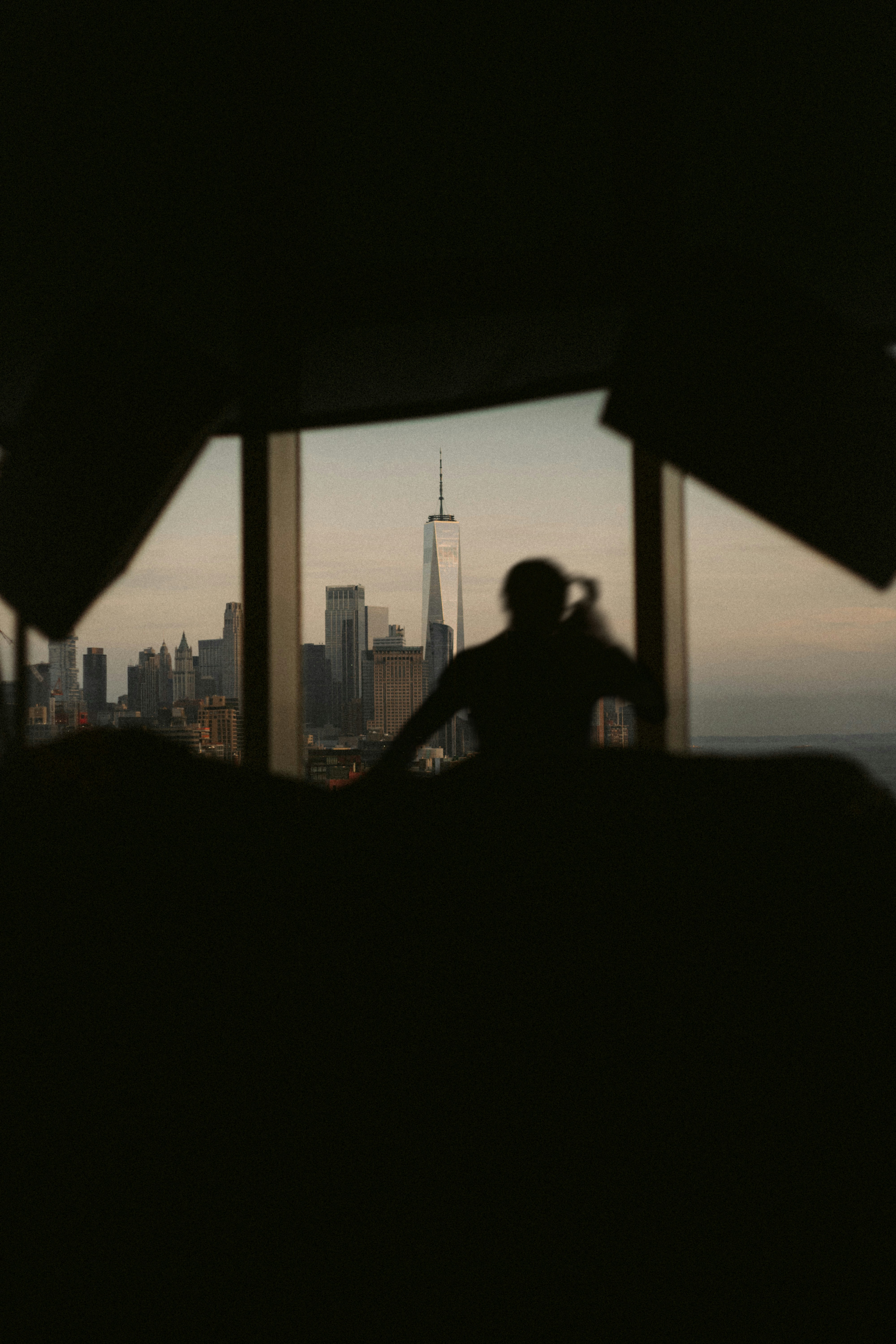 A person standing in front of a window with a view of a city