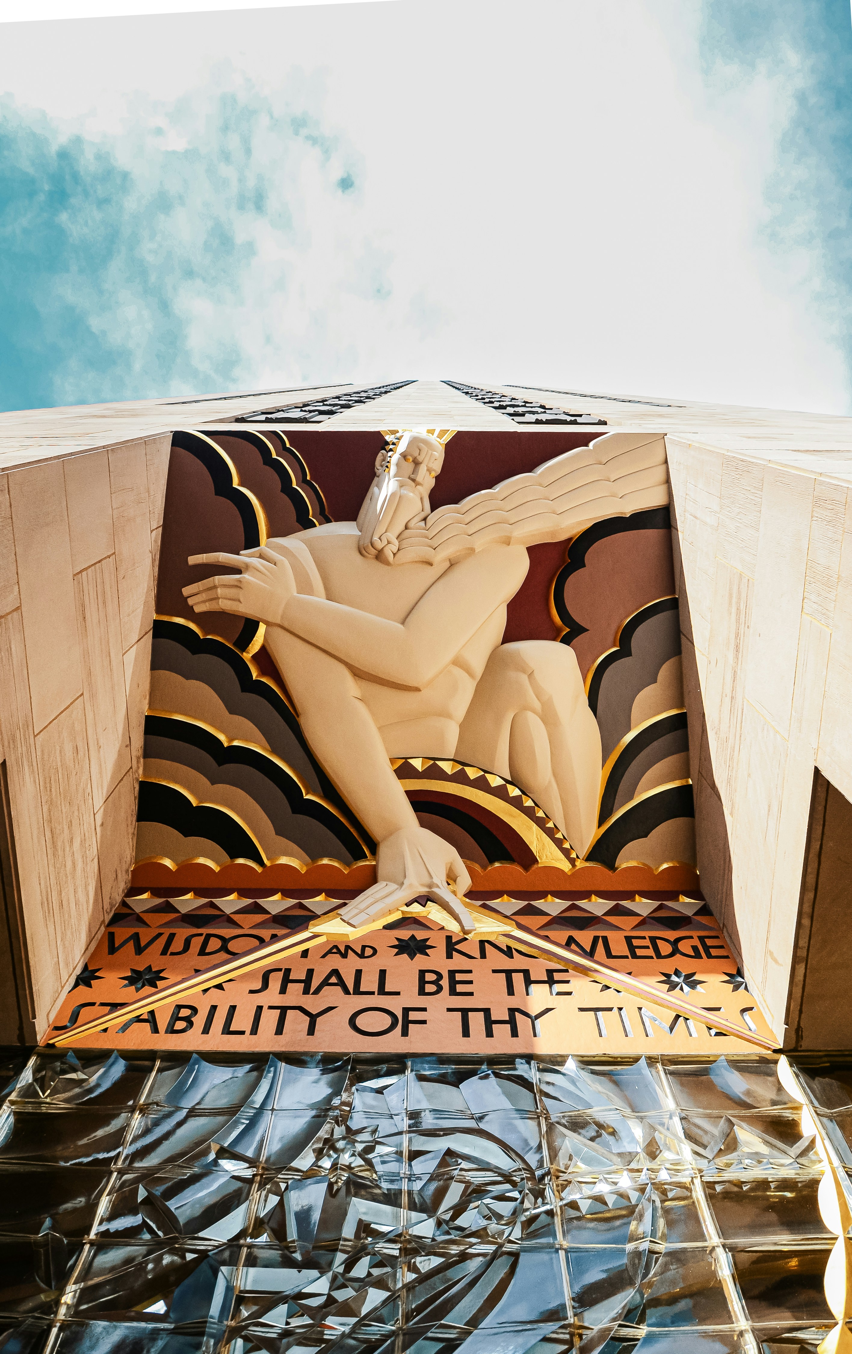 A wooden sculpture of a man with wings on top of a building