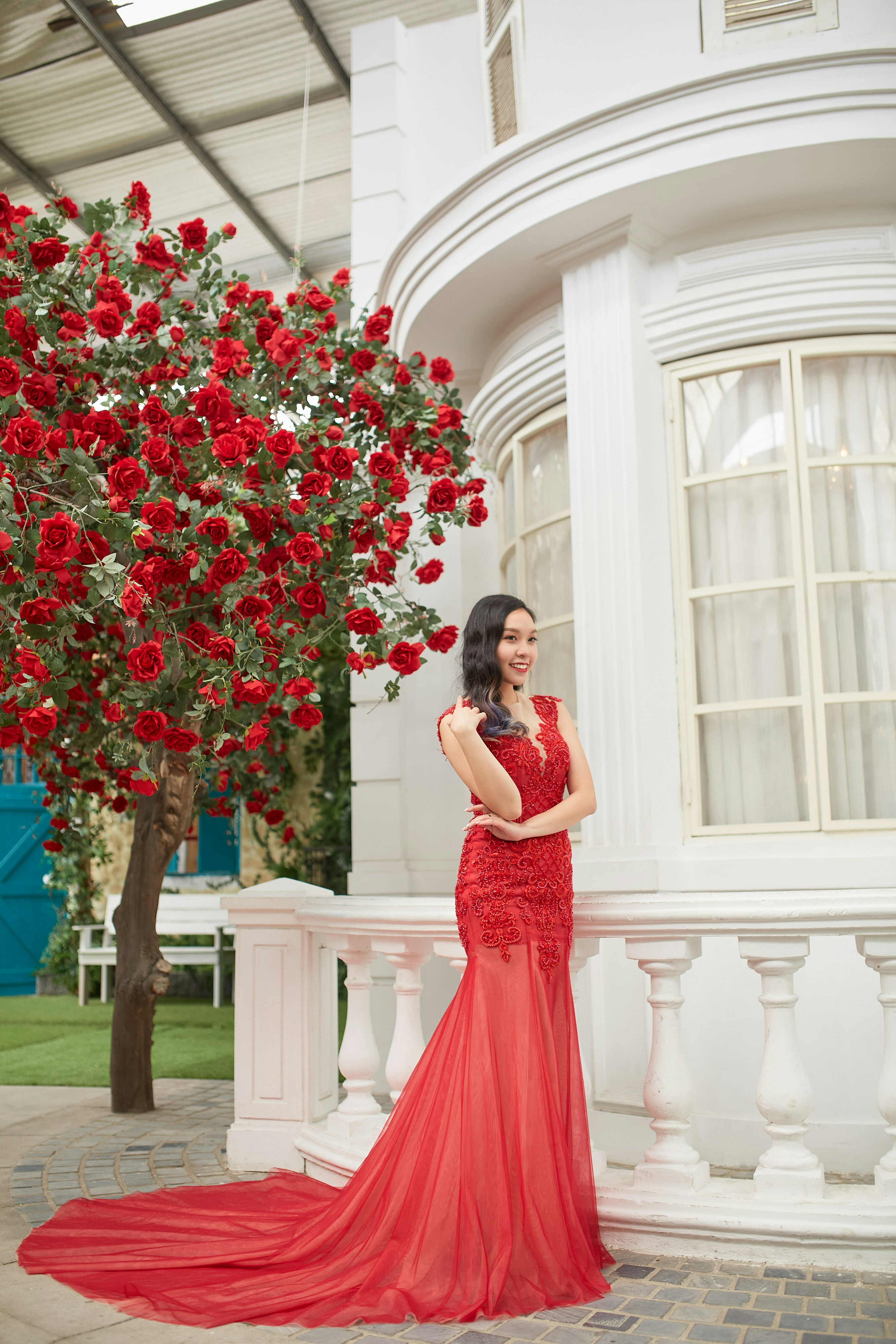 A woman in a red dress standing in front of a tree photo – Free Flower ...
