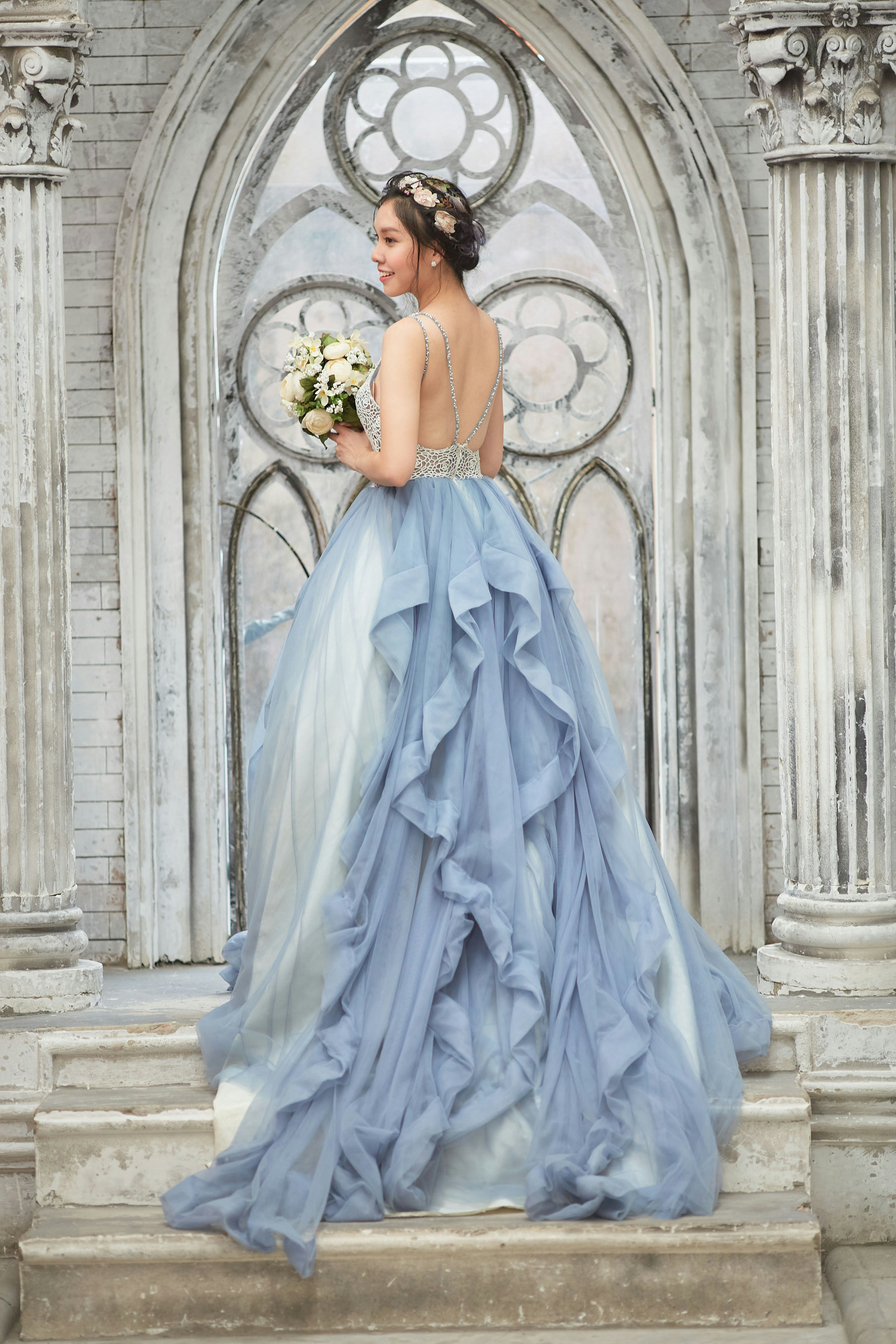 A woman in a blue dress standing on steps photo – Free Flower Image on ...