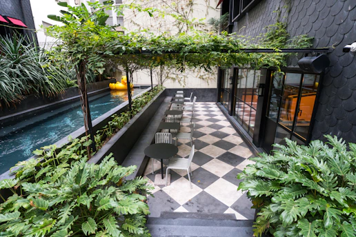 A courtyard with a checkerboard floor and green plants