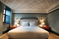 A large bed sitting in a bedroom next to a window