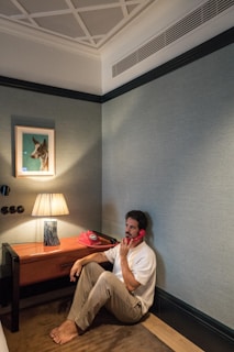 A man sitting on the floor talking on a cell phone