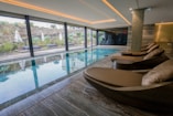 A large indoor swimming pool with lounge chairs
