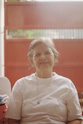 An older woman sitting in a chair with a baby seat