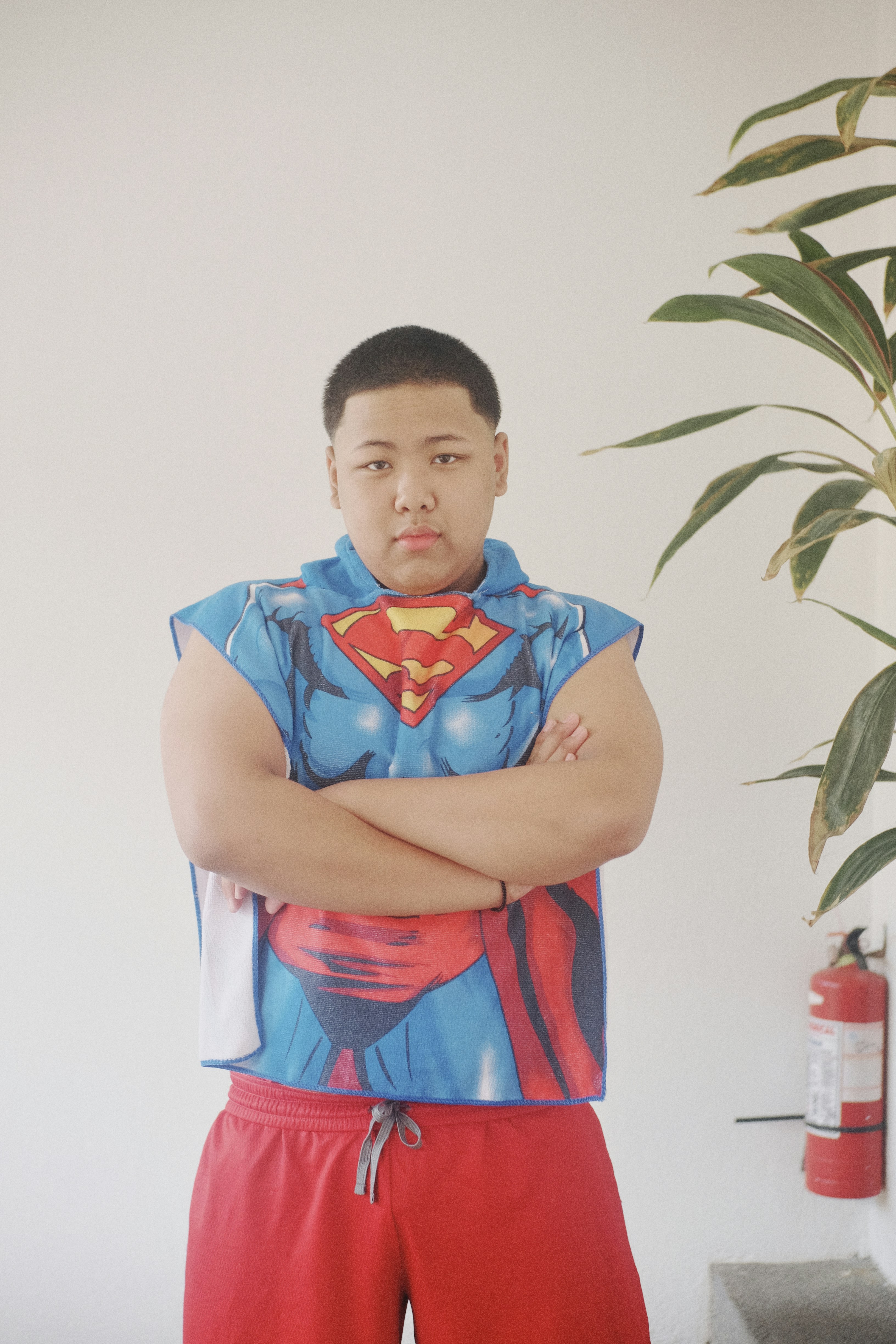 A man in a superman costume standing with his arms crossed