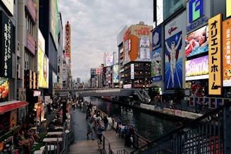 A group of people walking down a street next to tall buildings