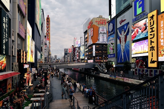 A group of people walking down a street next to tall buildings