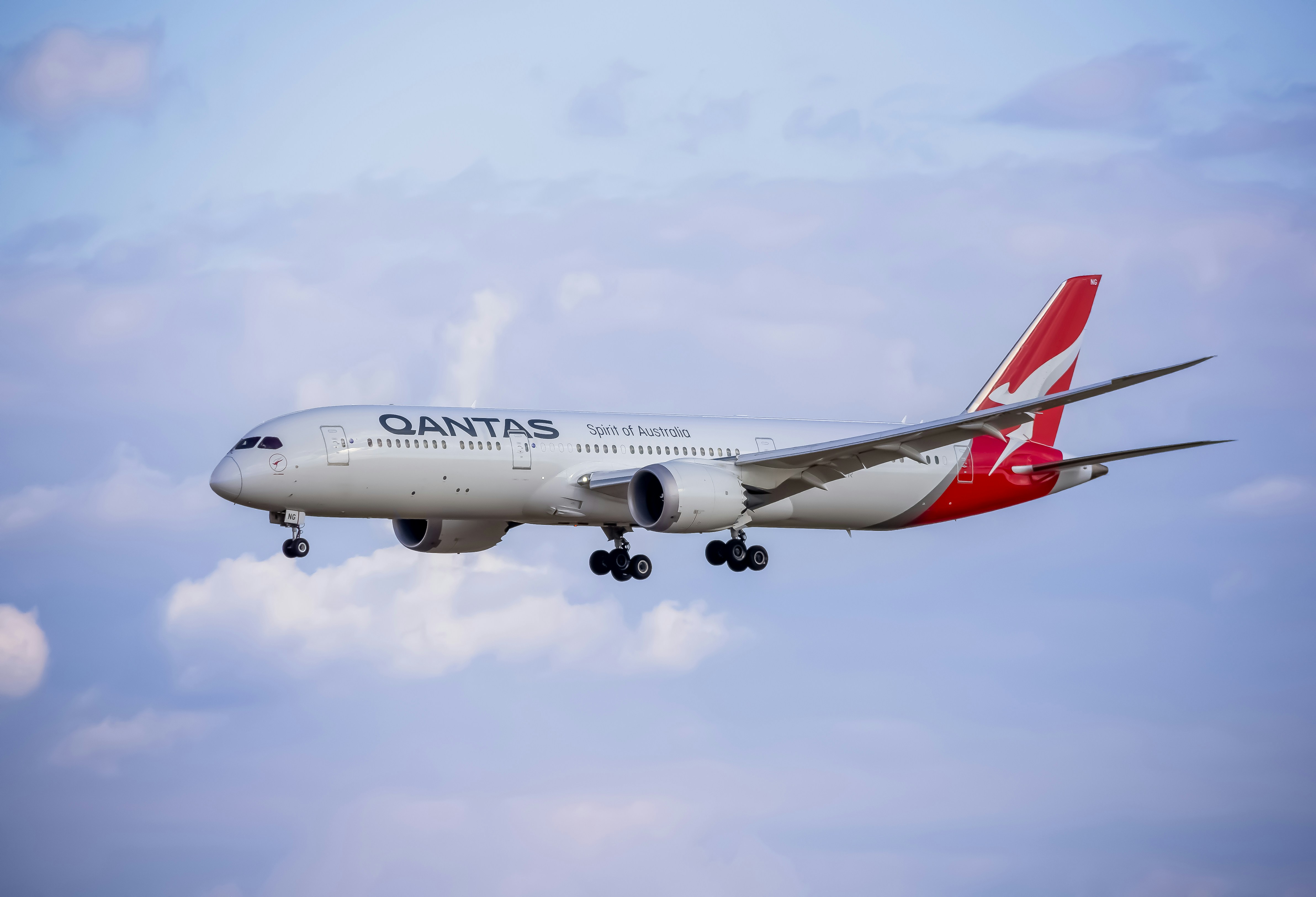 A large jetliner flying through a blue cloudy sky
